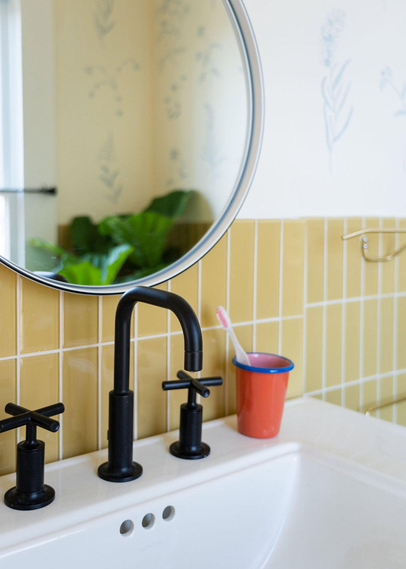 The Grant Mirror in white in a tiled bathroom. 