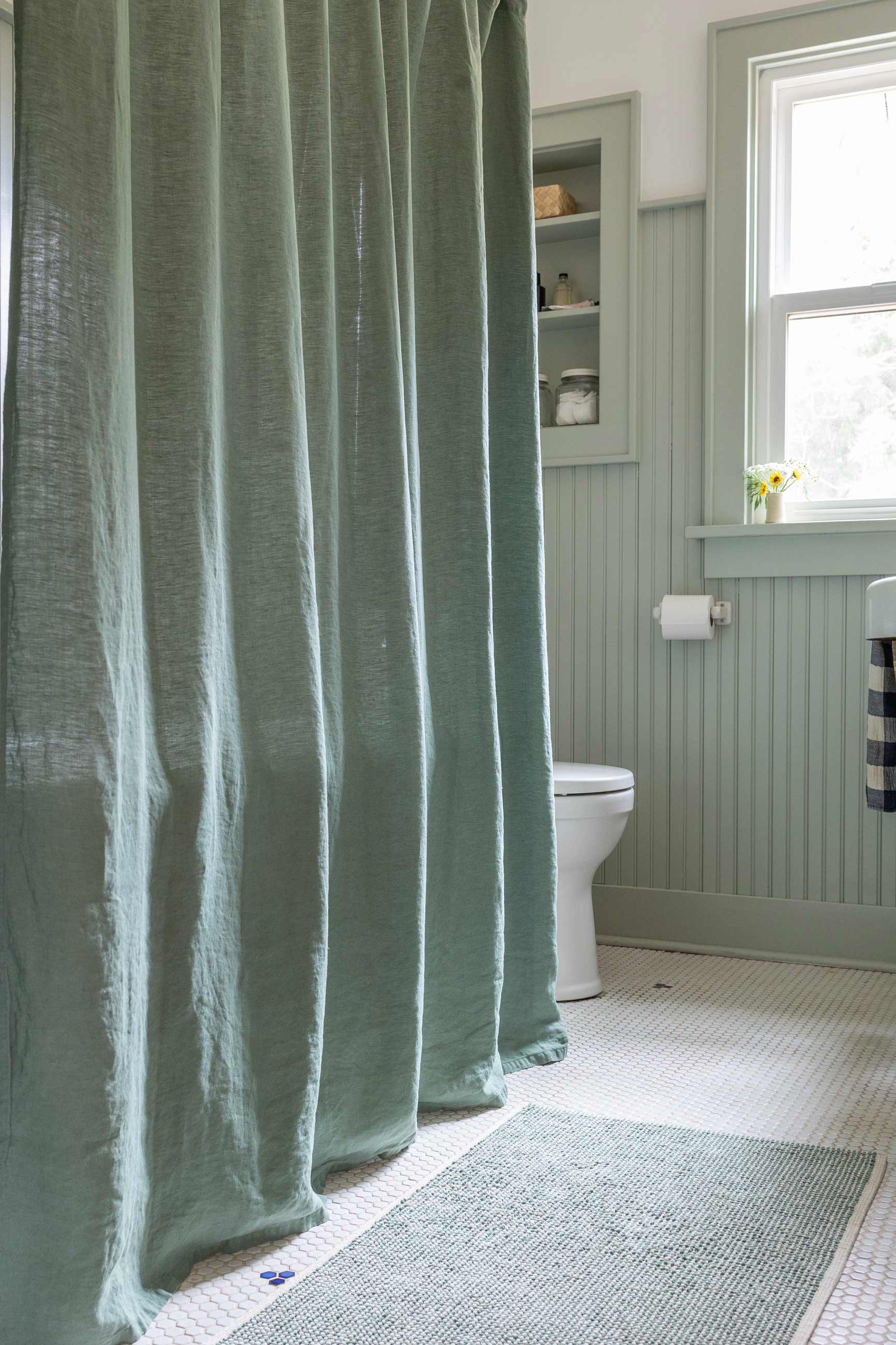 Green bathroom with green shower curtain. 