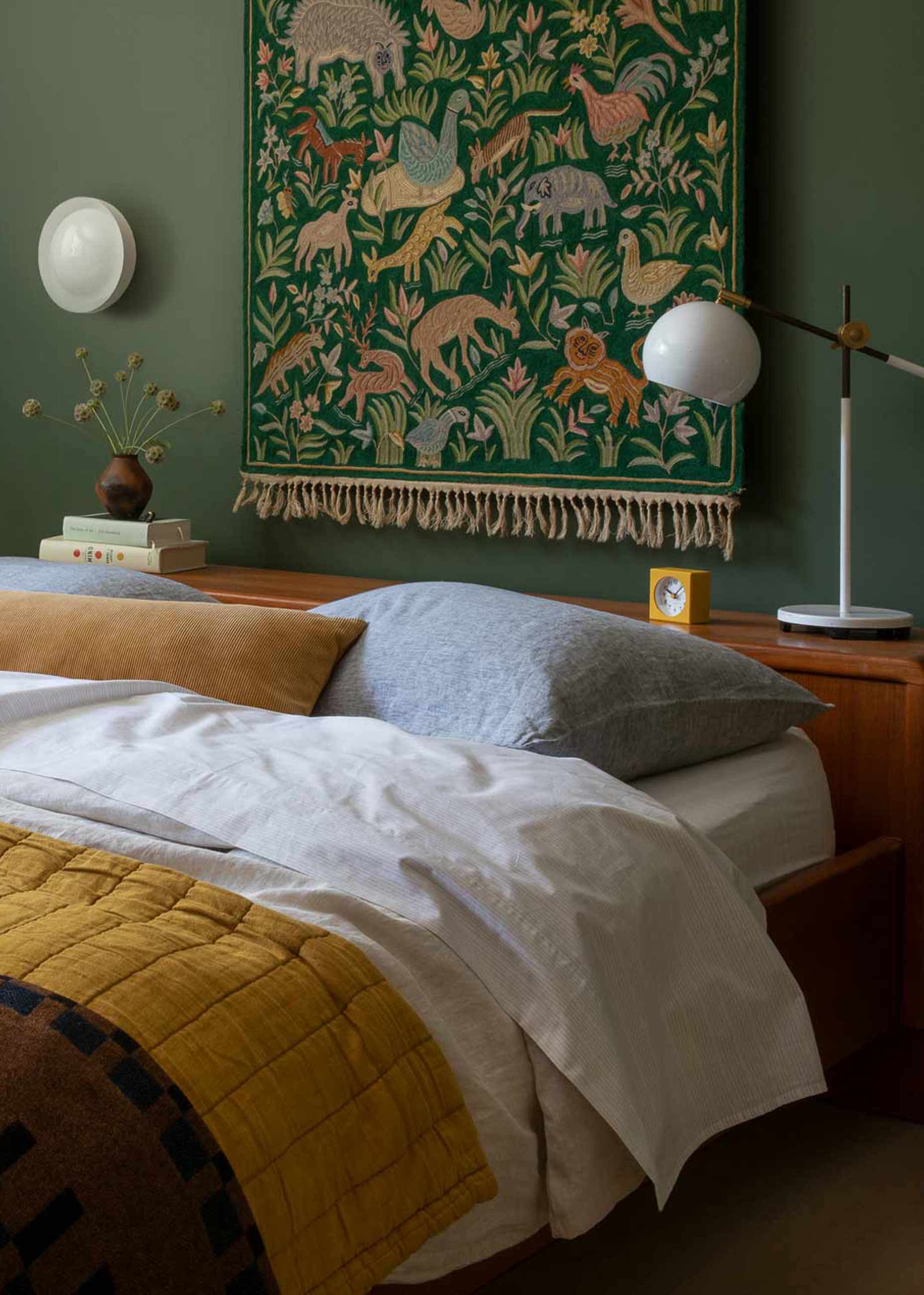 Green bedroom with mid century furniture and white accents. 