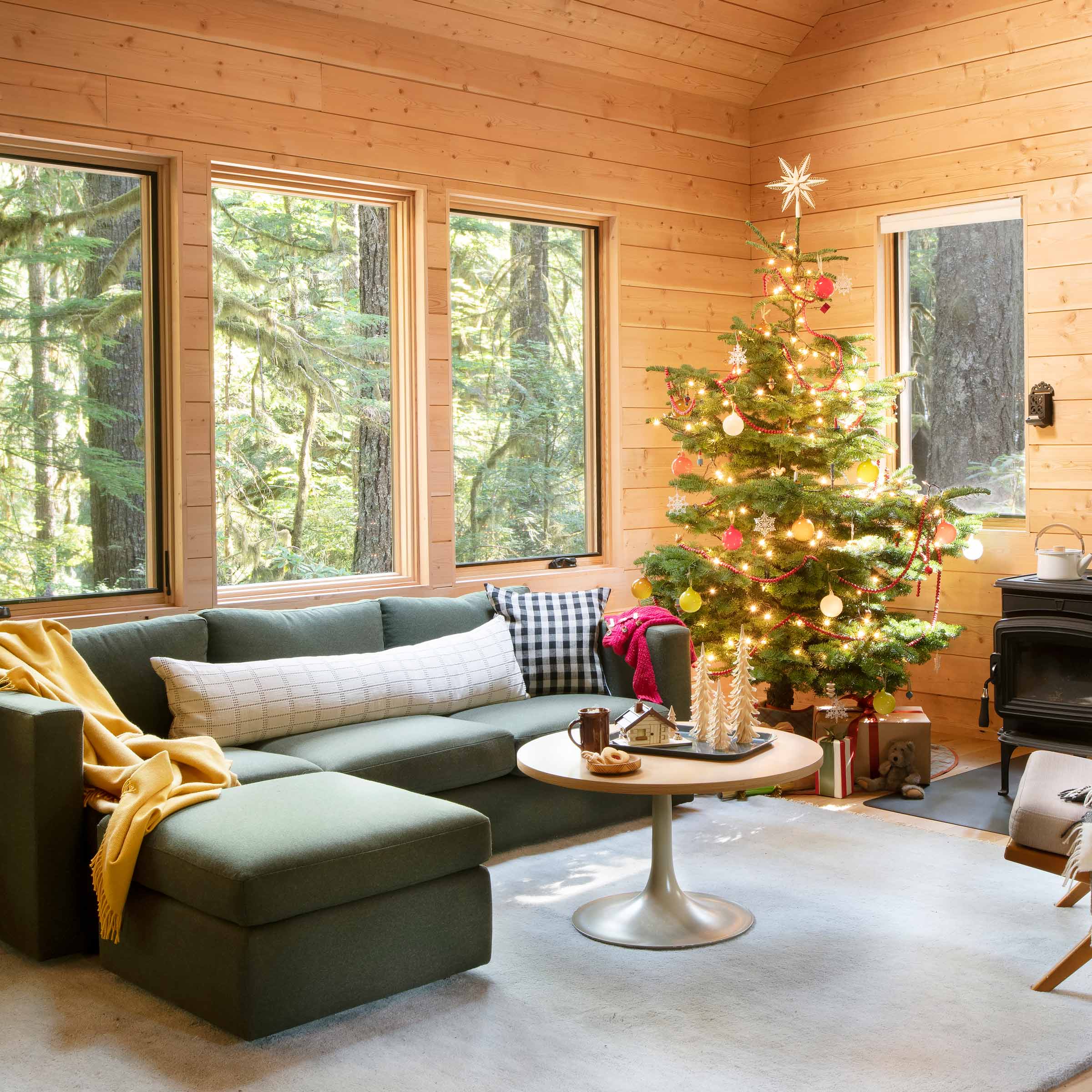 Living room of a cabin in the woods decorated for the holidays.