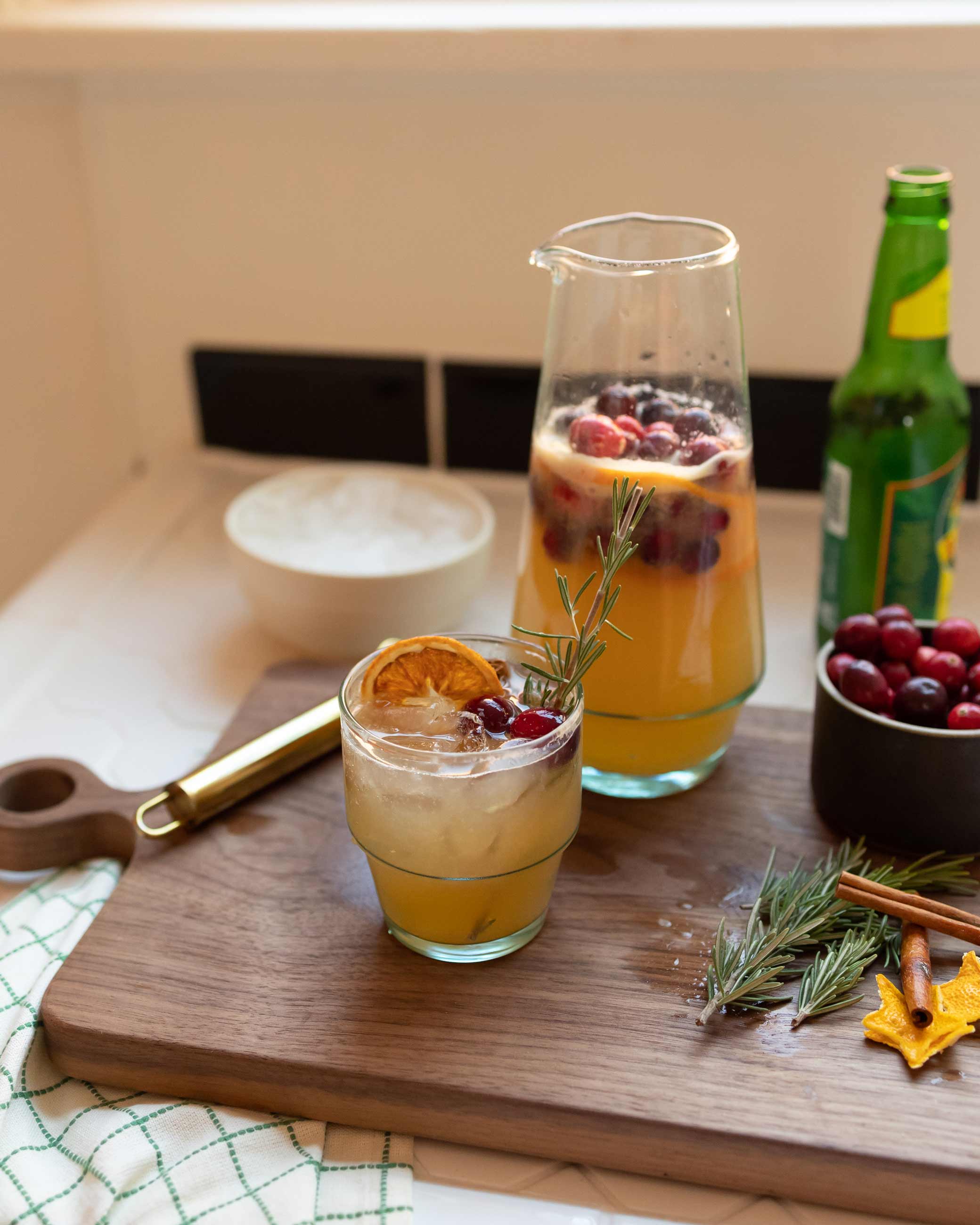 Holiday mocktail sitting on wood cutting board.