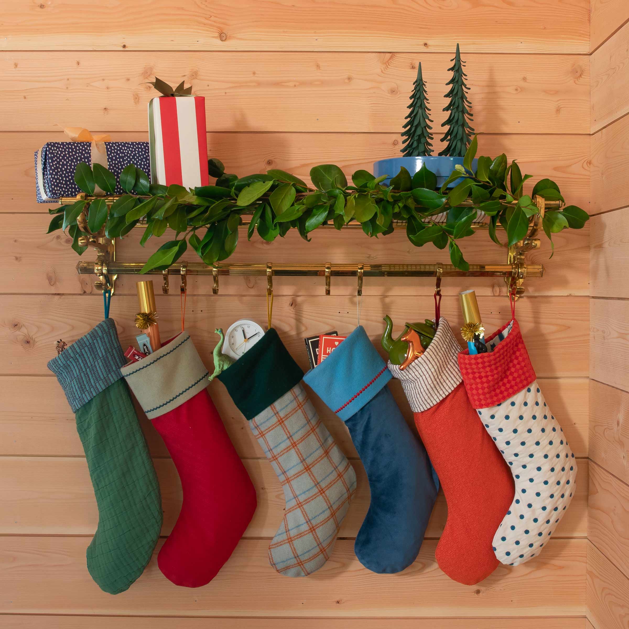 Holiday stockings hanging on an entryway coat rack.