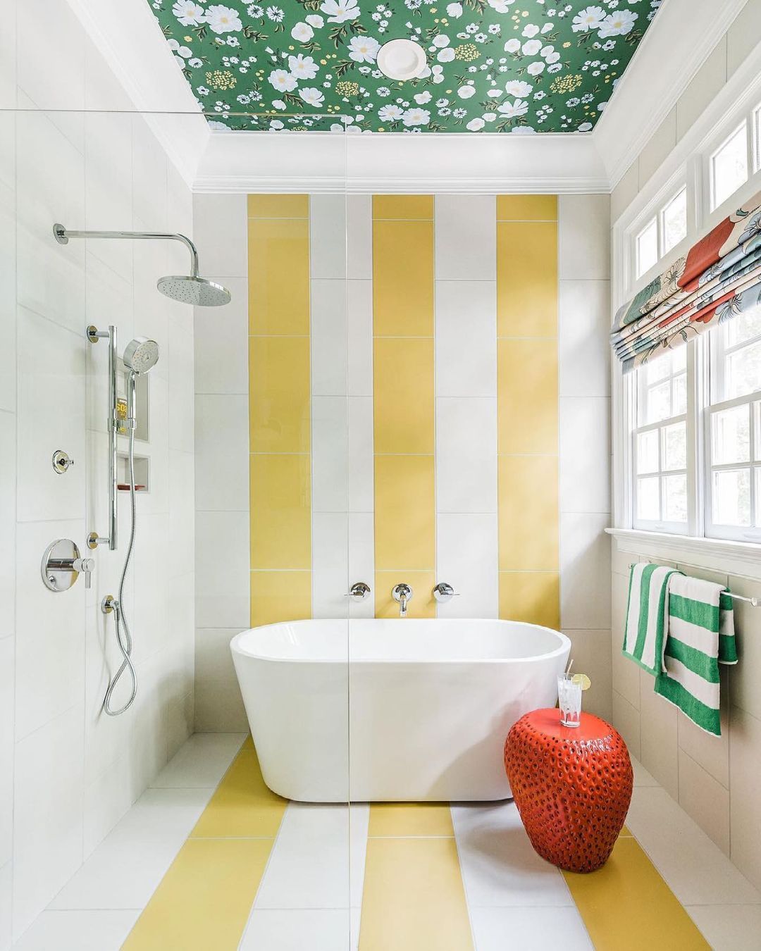 bathroom with a tub and shower and white and yellow striped walls and floor