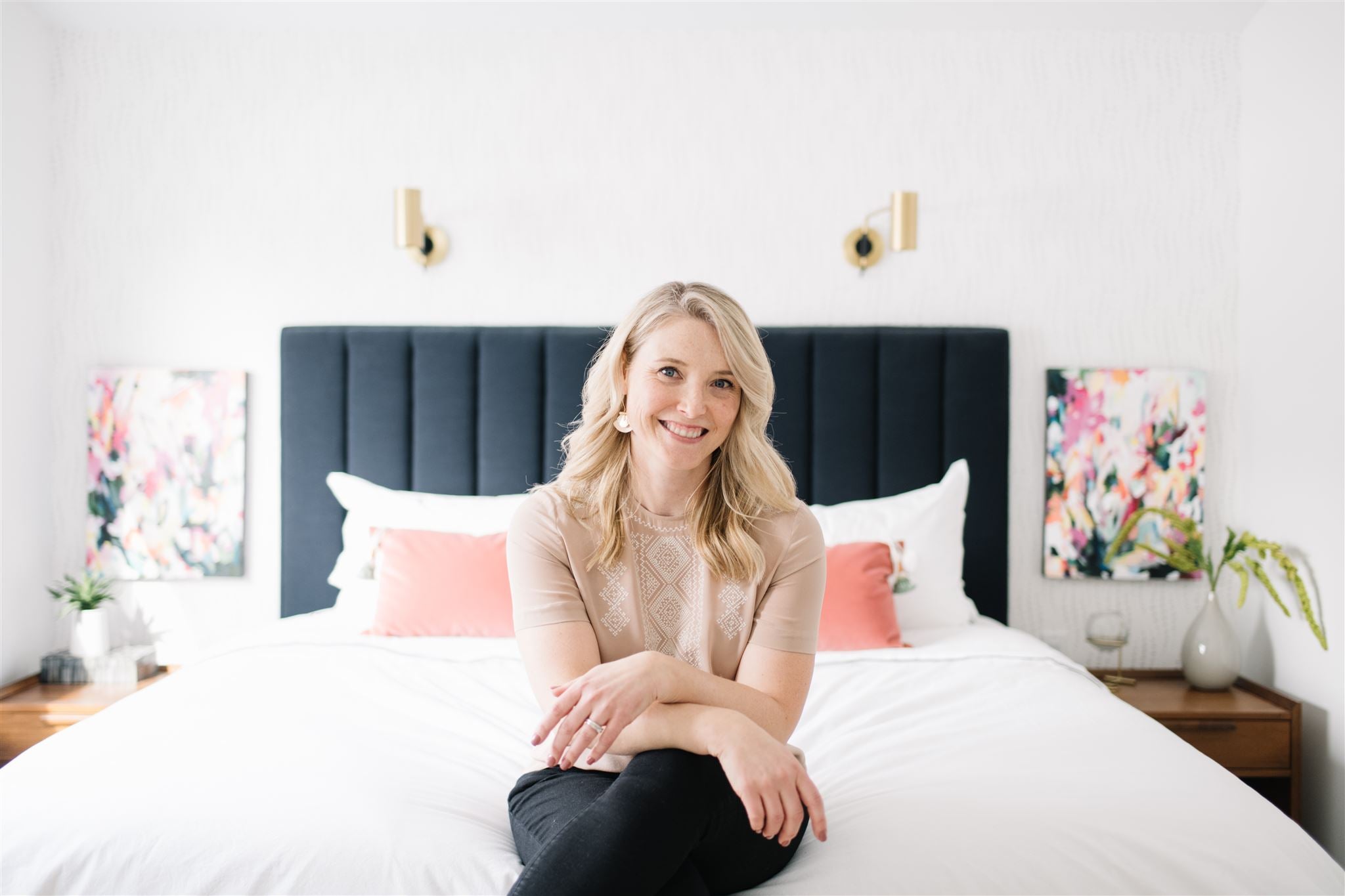 woman sitting at the foot of a bed