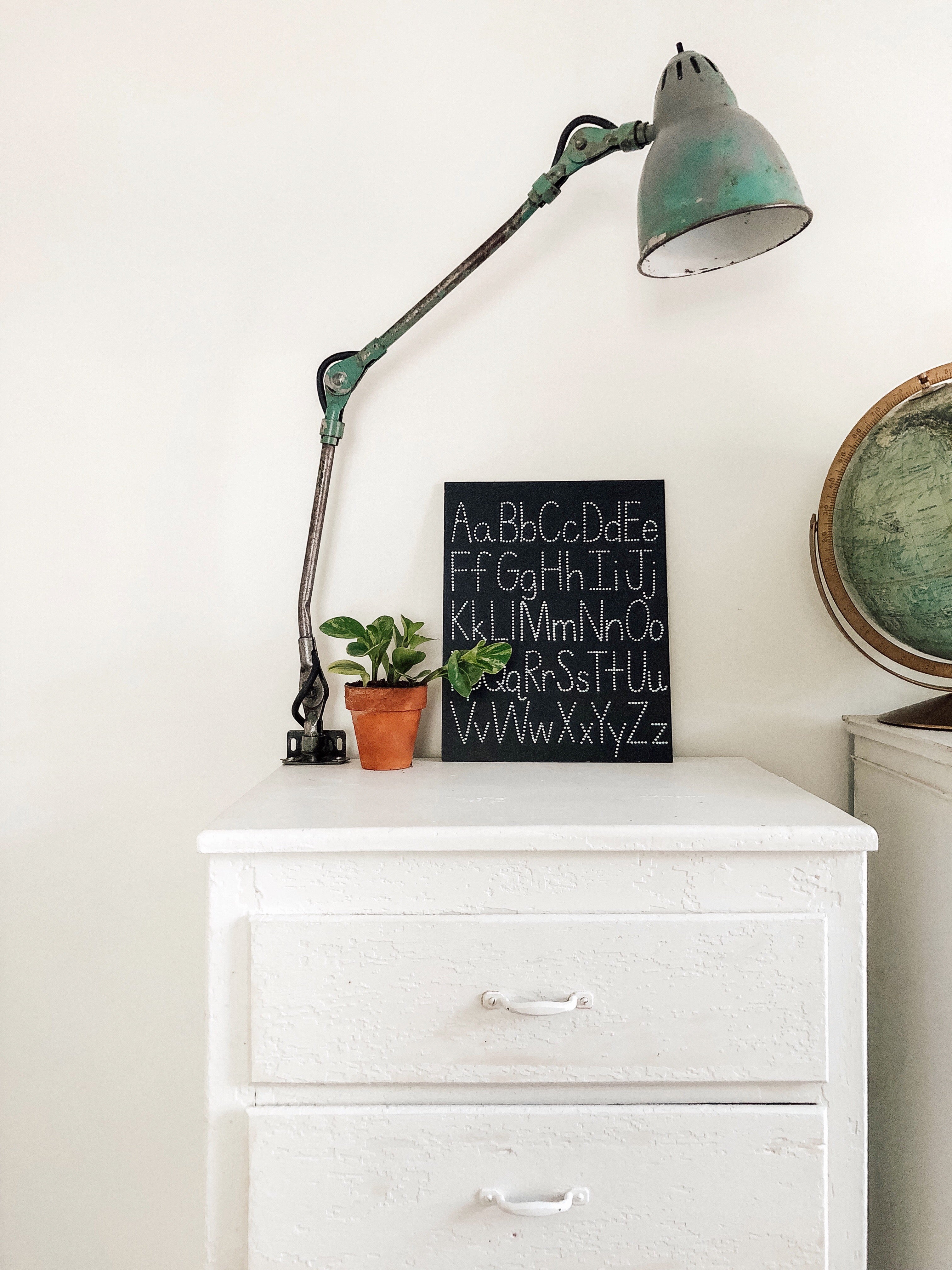 white dresser with a blue lamp on top of it