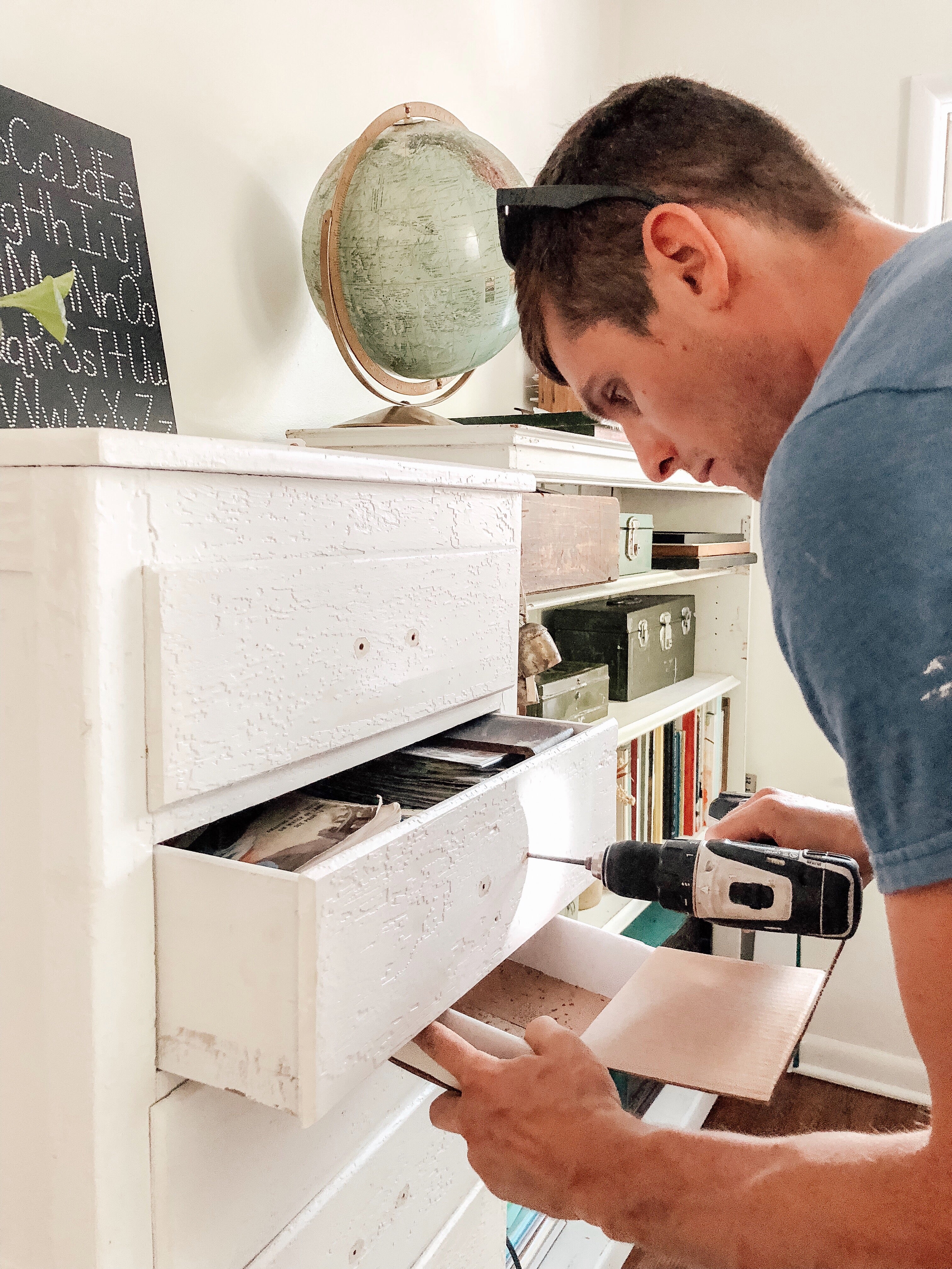 man drilling a dresser drawer