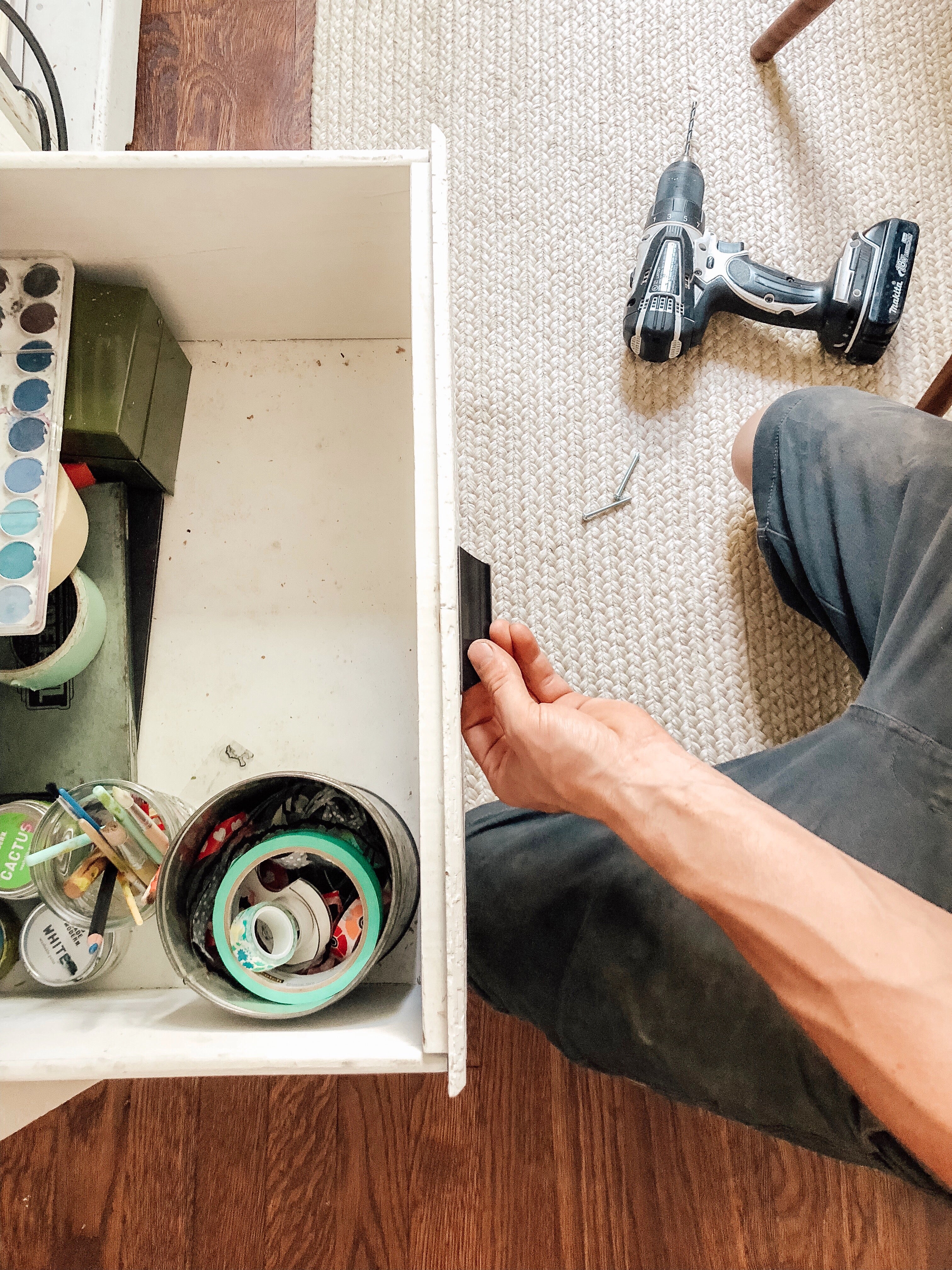 person installing handles on a dresser