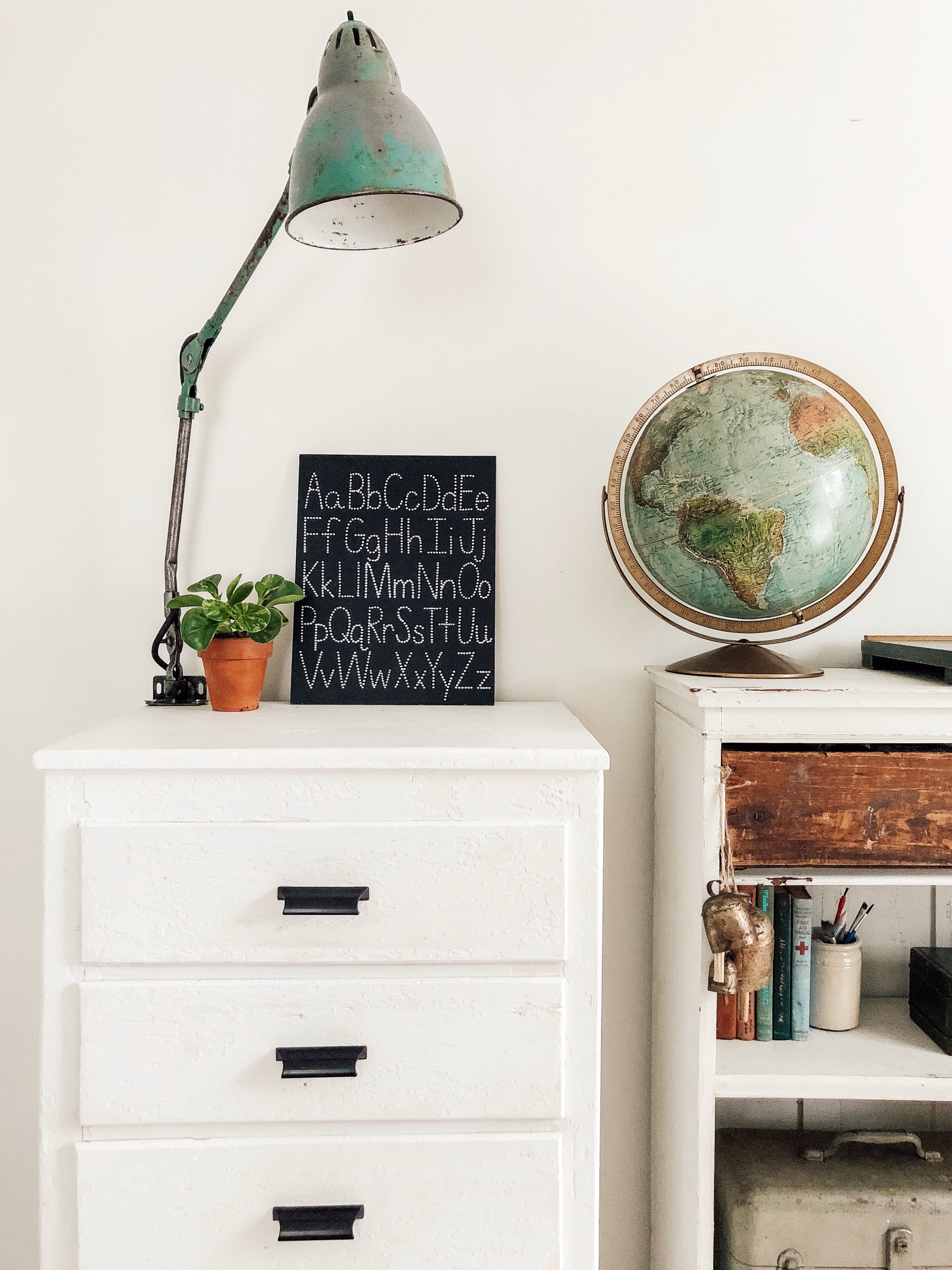 white dresser with a blue lamp on top of it