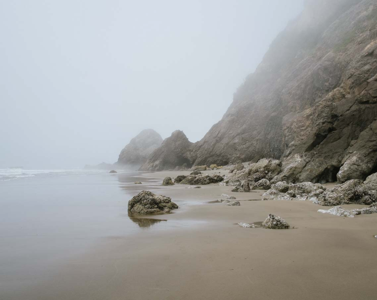 foggy beach with rocks and water