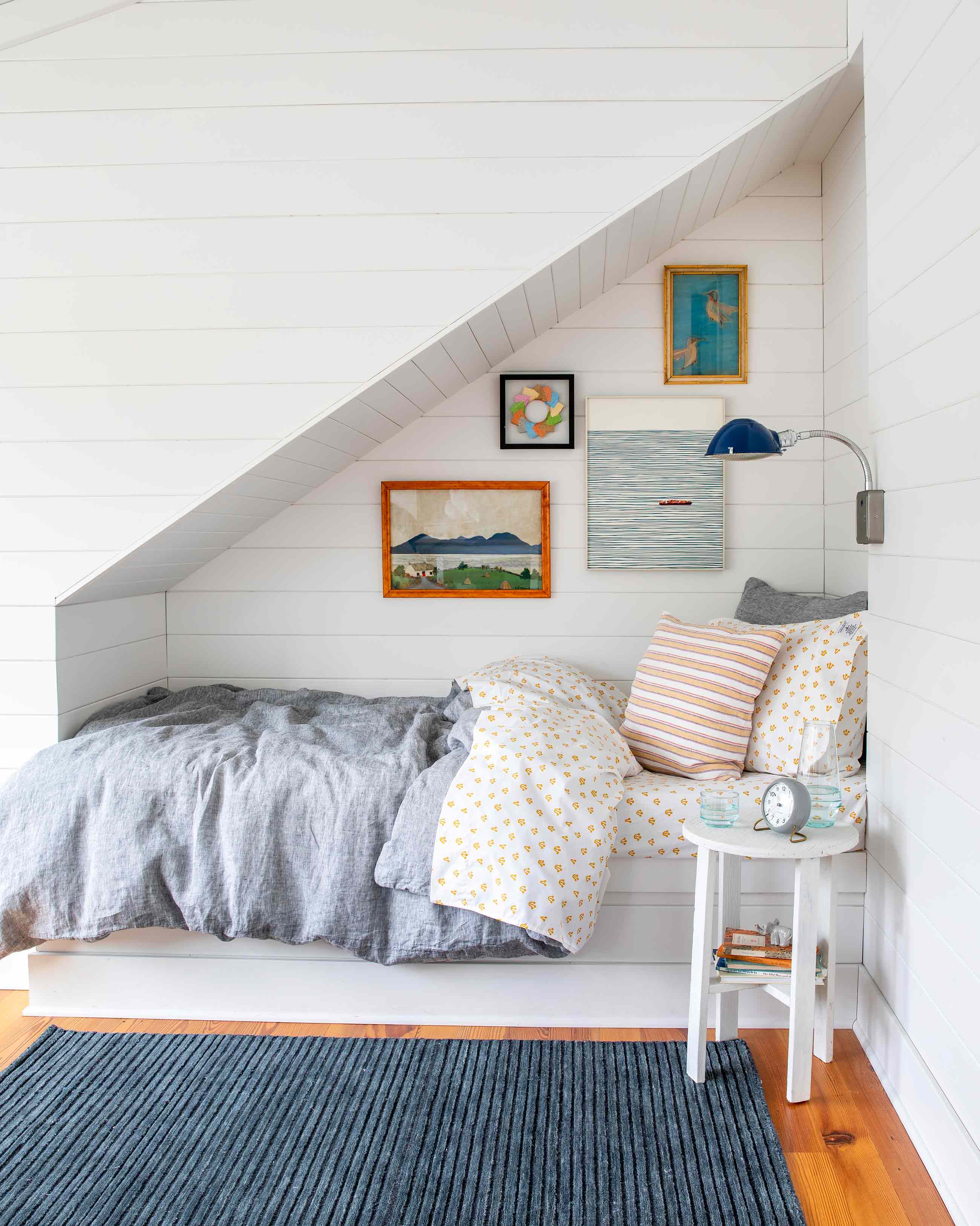 Kid's bedroom nook with patterned bedding and navy rug