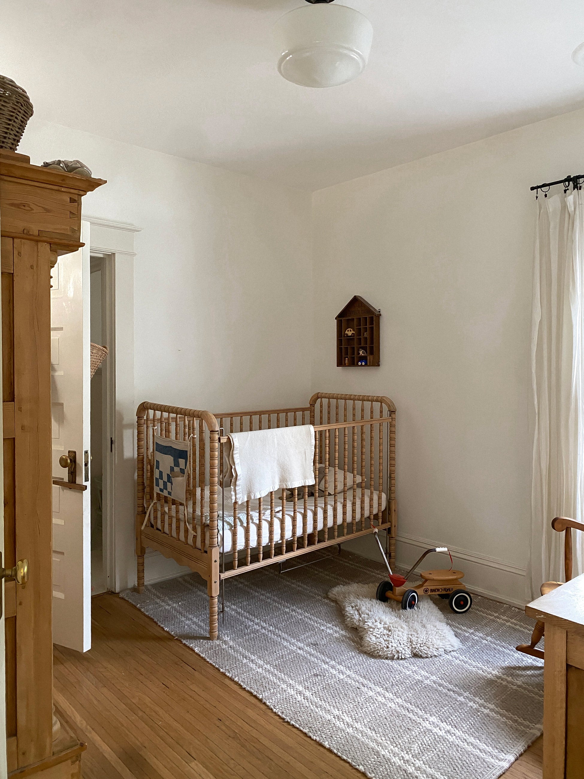 Sweet and simple kids bedroom with a wooden crib in the corner. 