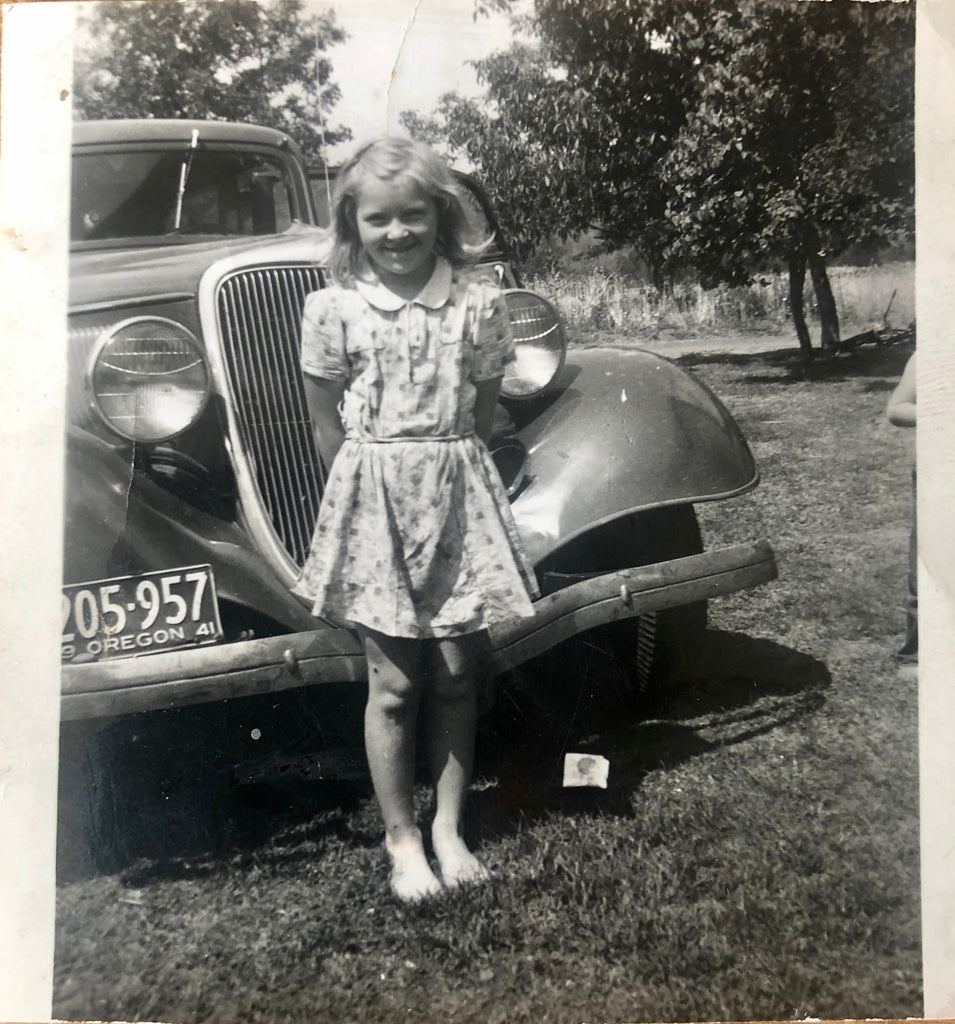 little girl standing in front of car