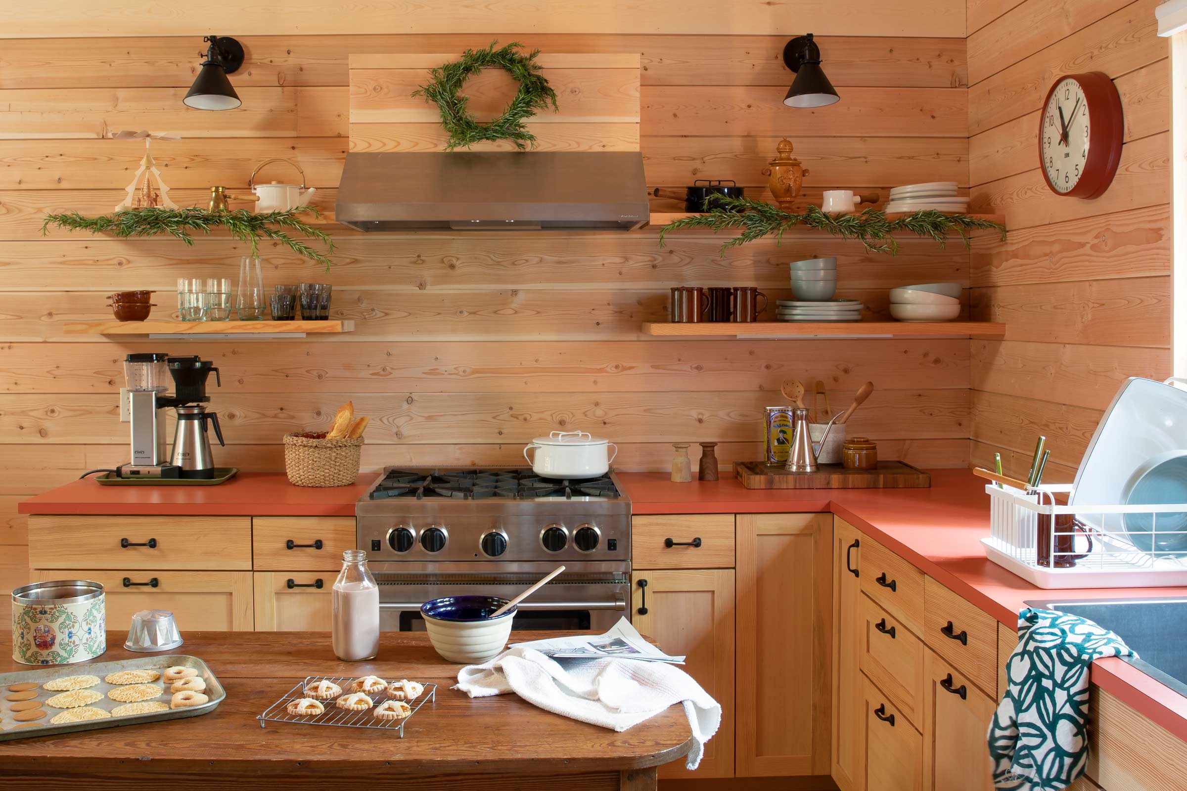 Kitchen in a cabin with open shelving and holiday garland.