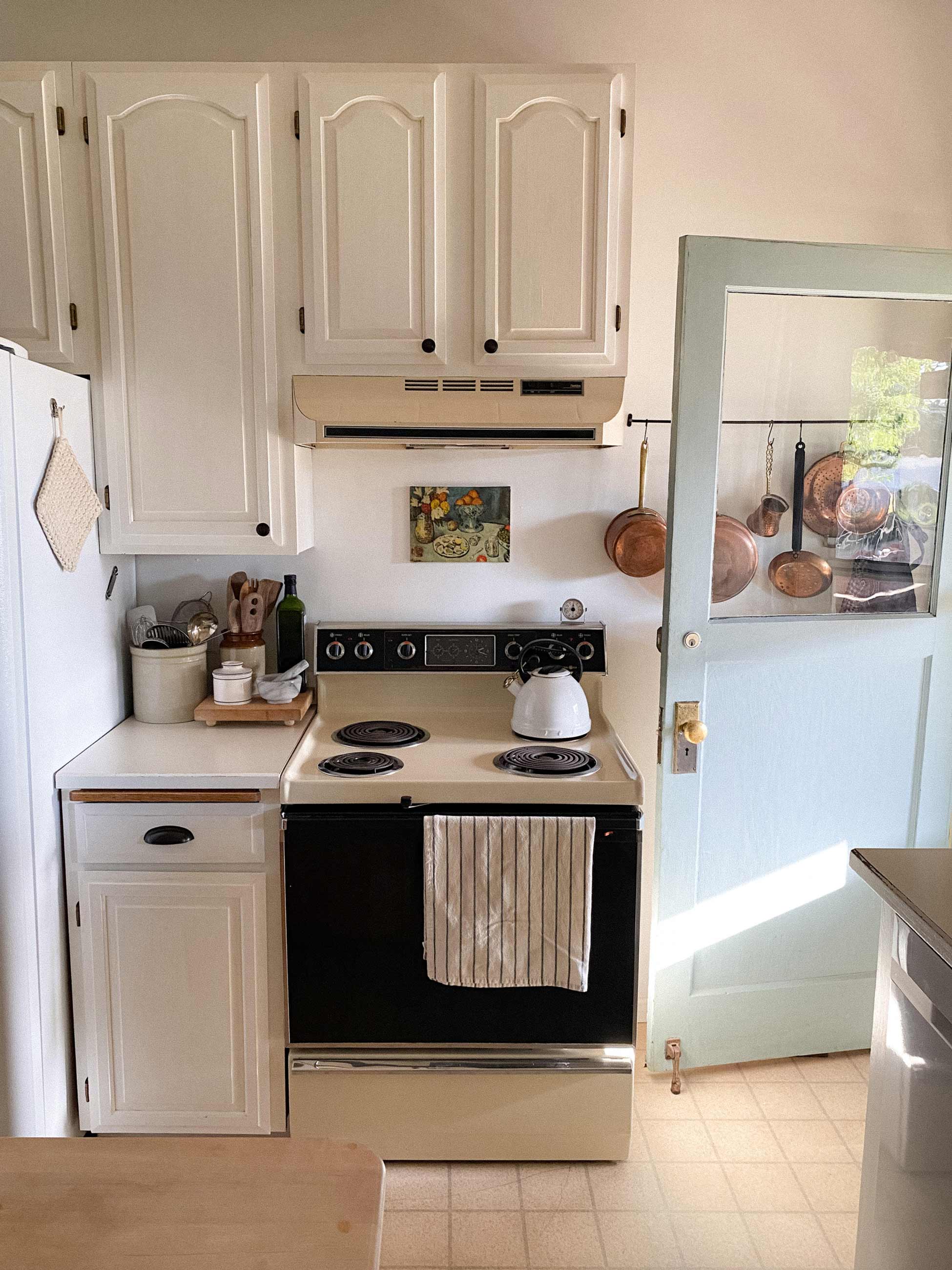 Kitchen stove and countertops with back door open.