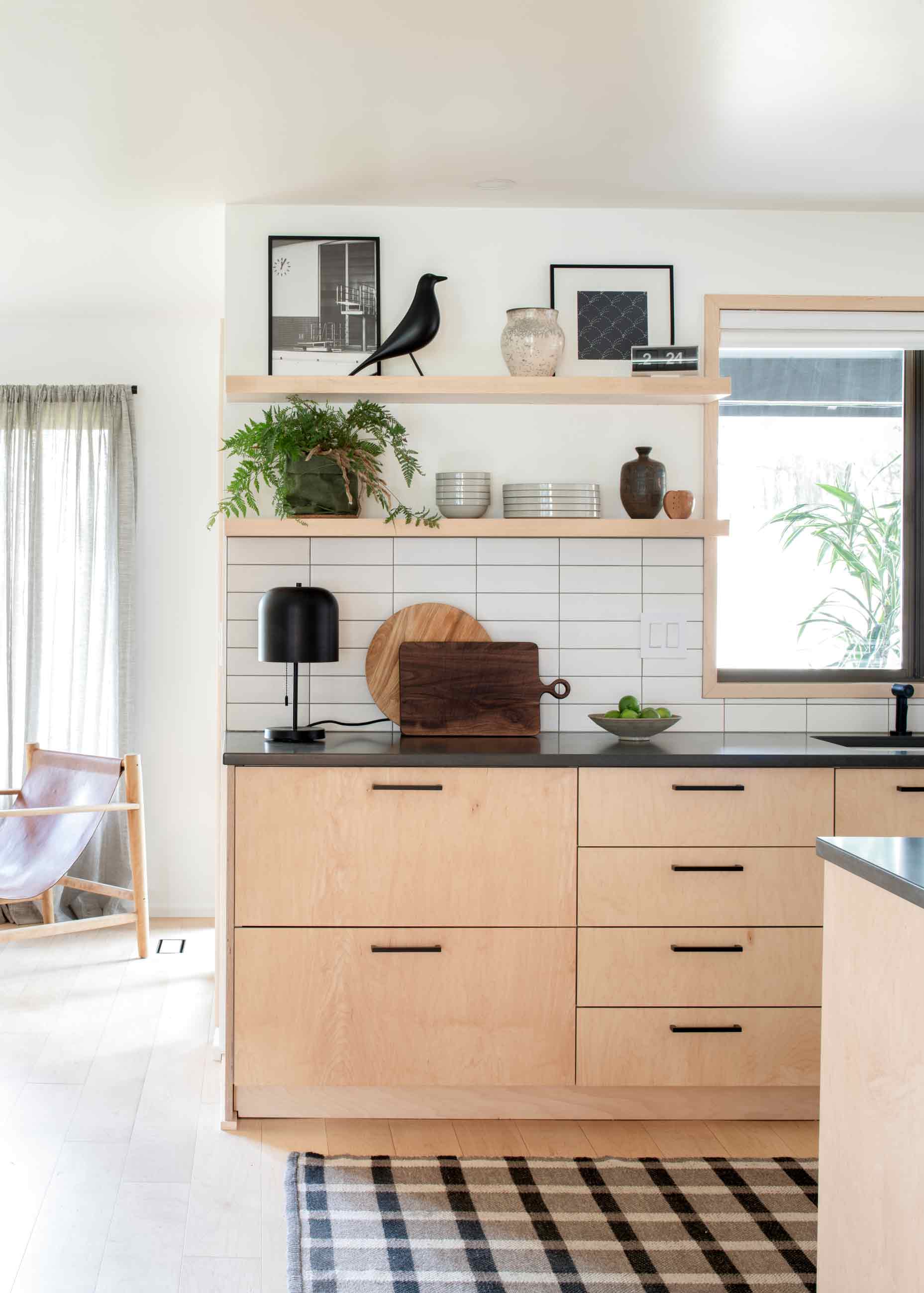 Light wood cabinets in kitchen with open shelving above counter. 