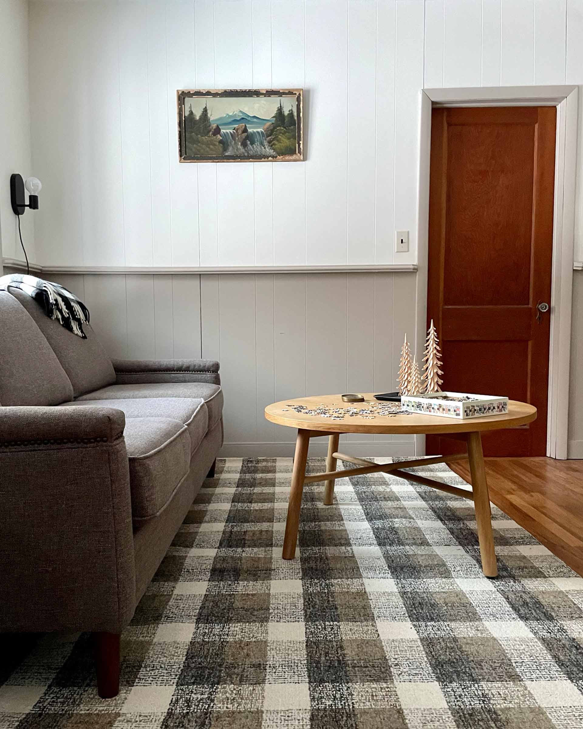 A cozy cabin living room with a plaid rug.