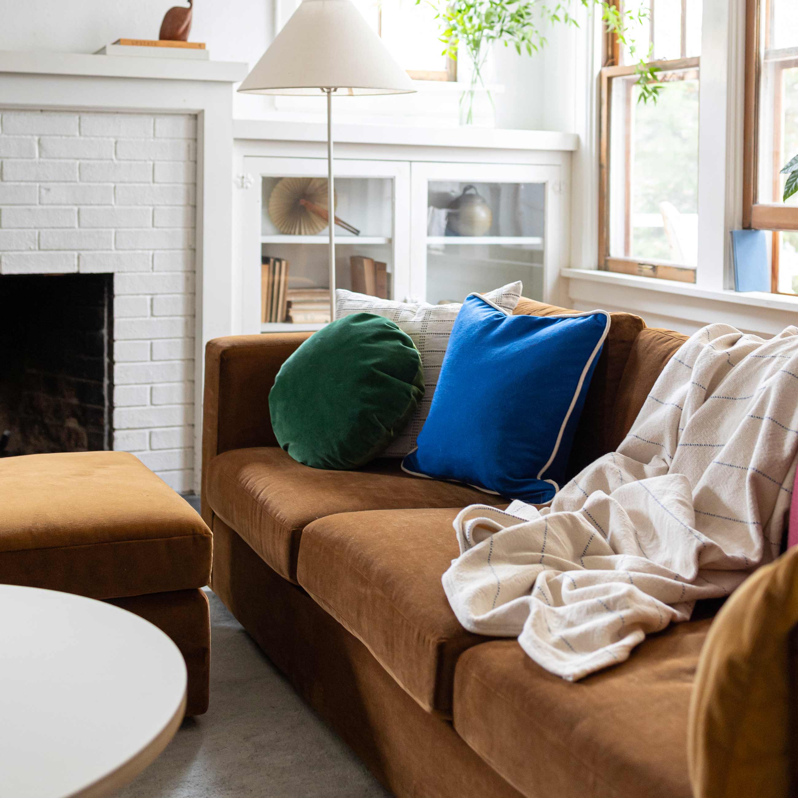 Brown sofa with colorful pillows on it.