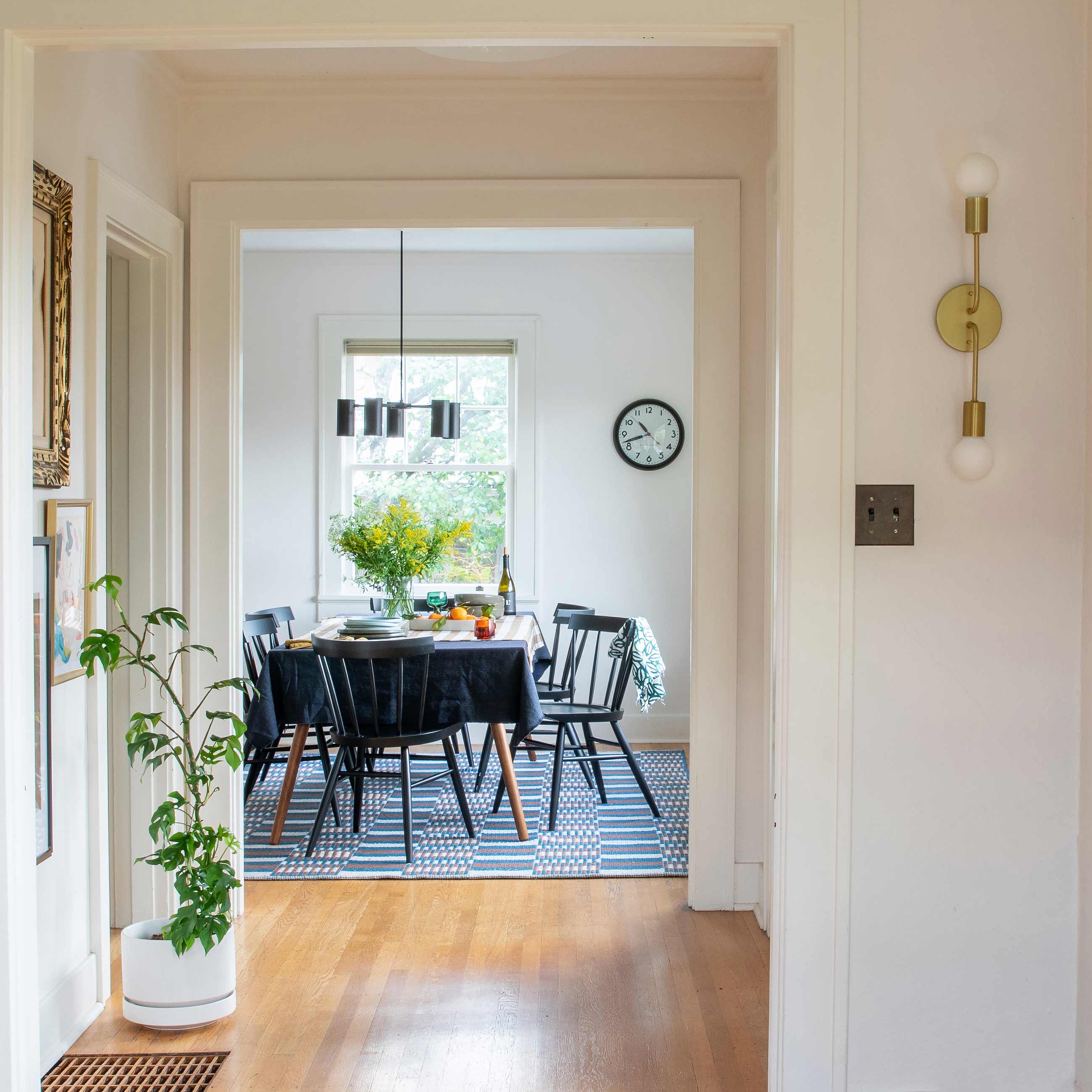 Clean dining room with chandelier above table.