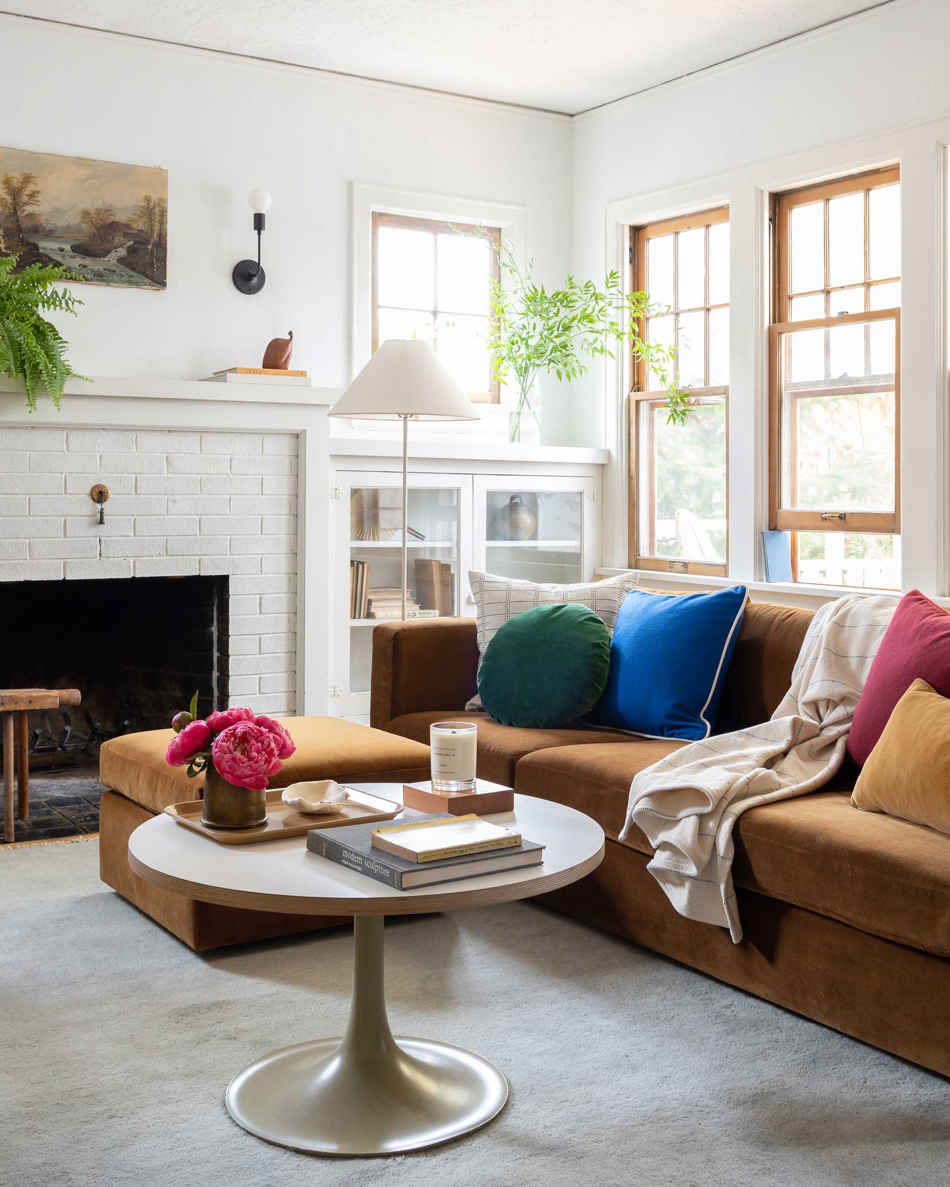 A bright mid century modern living room with throw pillows.