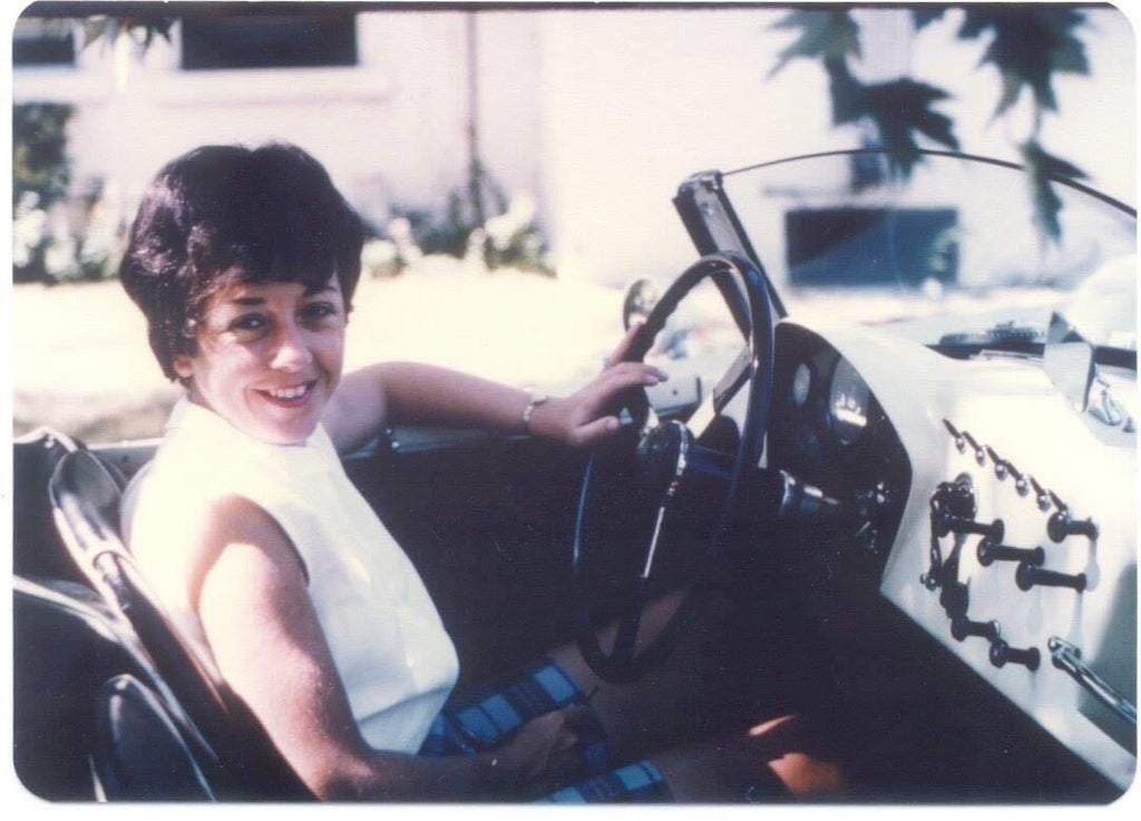woman in a tank top in the driver's seat of a car