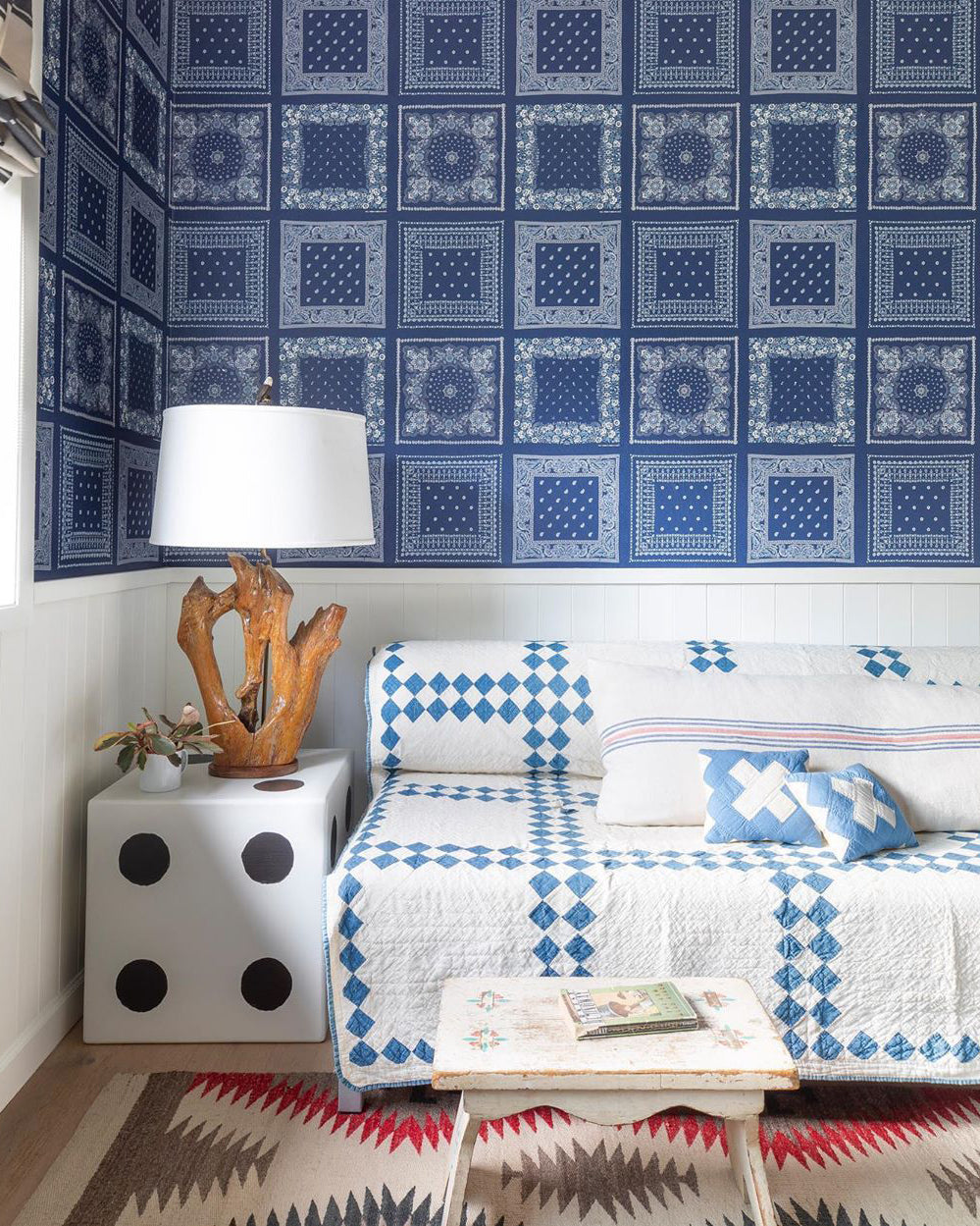 room with a bed and a lamp and blue wallpaper