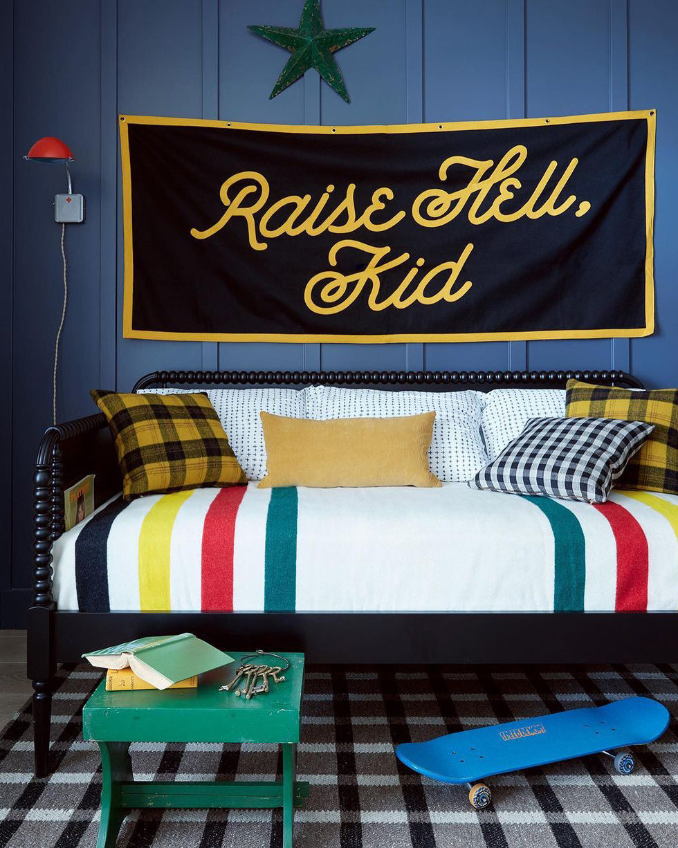 bed with a sign on the wall and colorful pillows