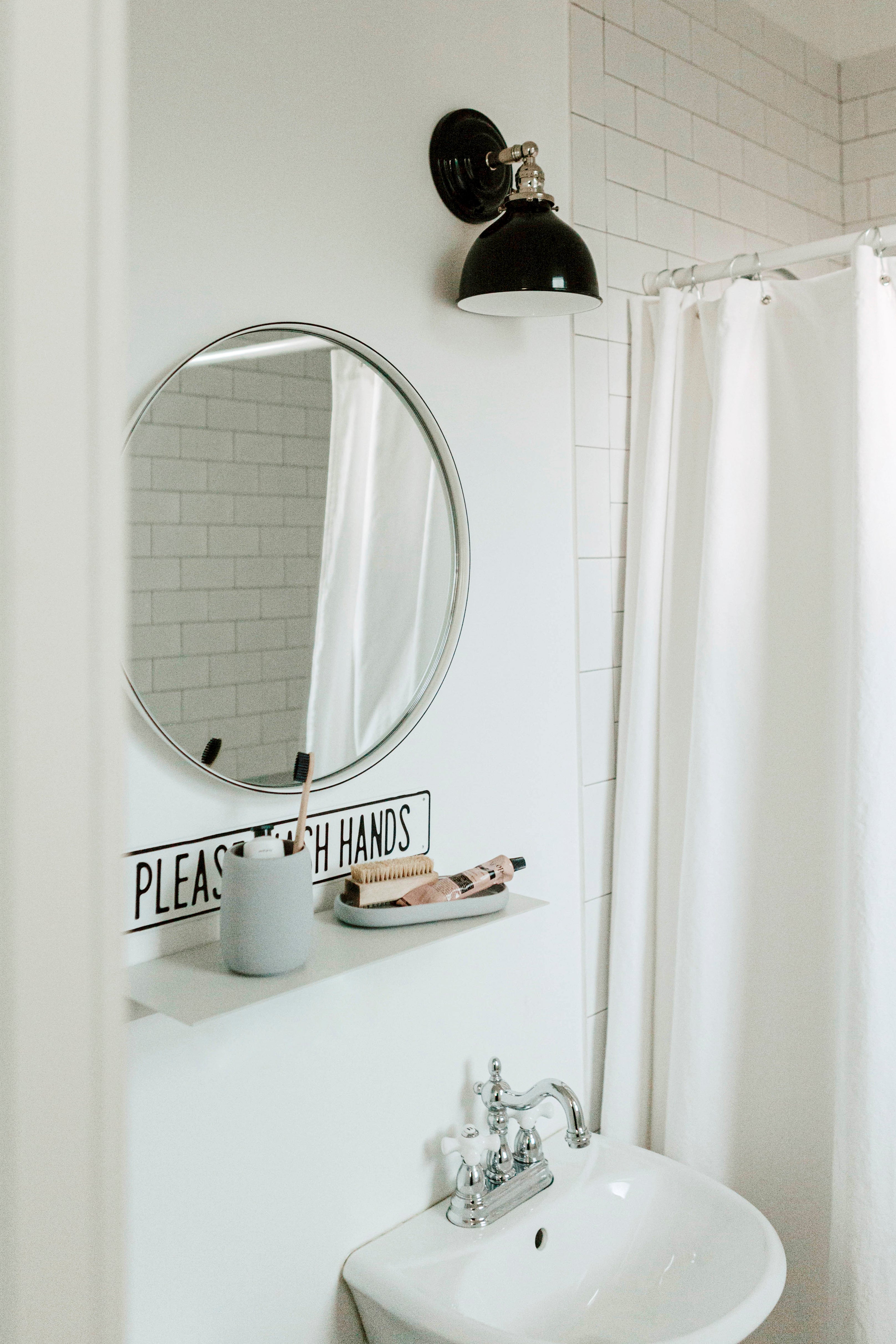 bathroom with a mirror and a sink and black sconce