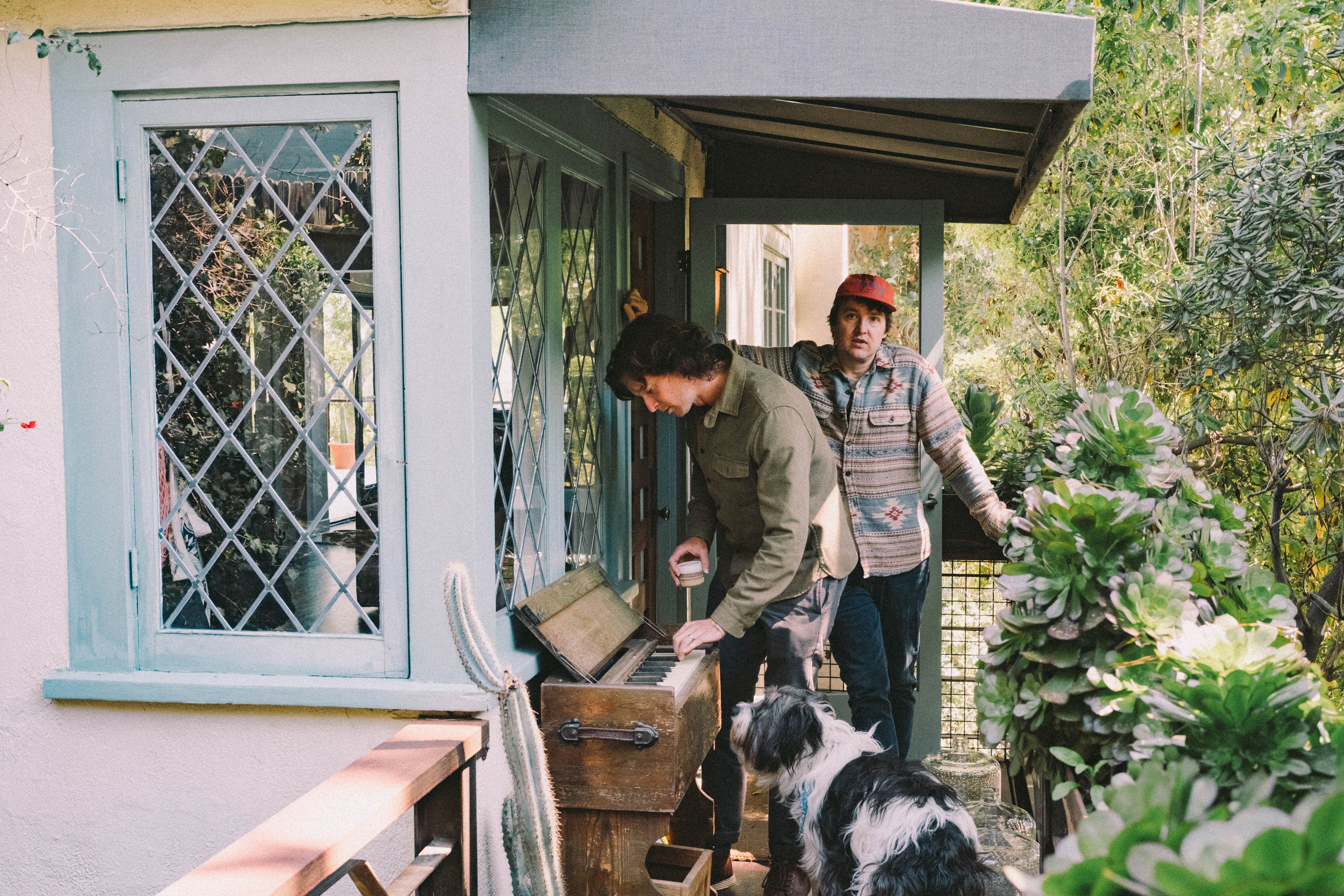 The Milk Carton Kids drinking coffee outside on the porch.