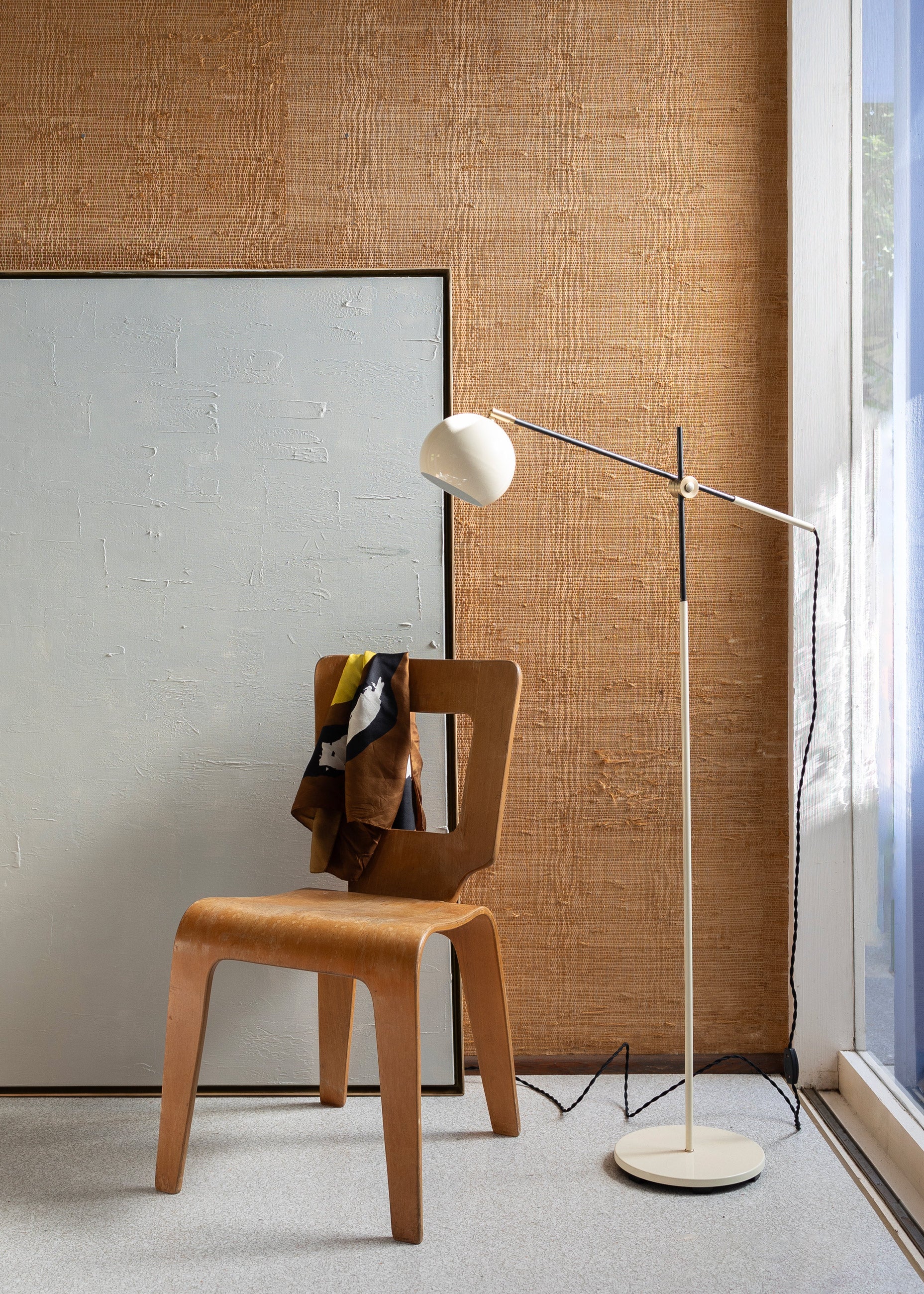 Floor lamp next to wooden chair in modern room.