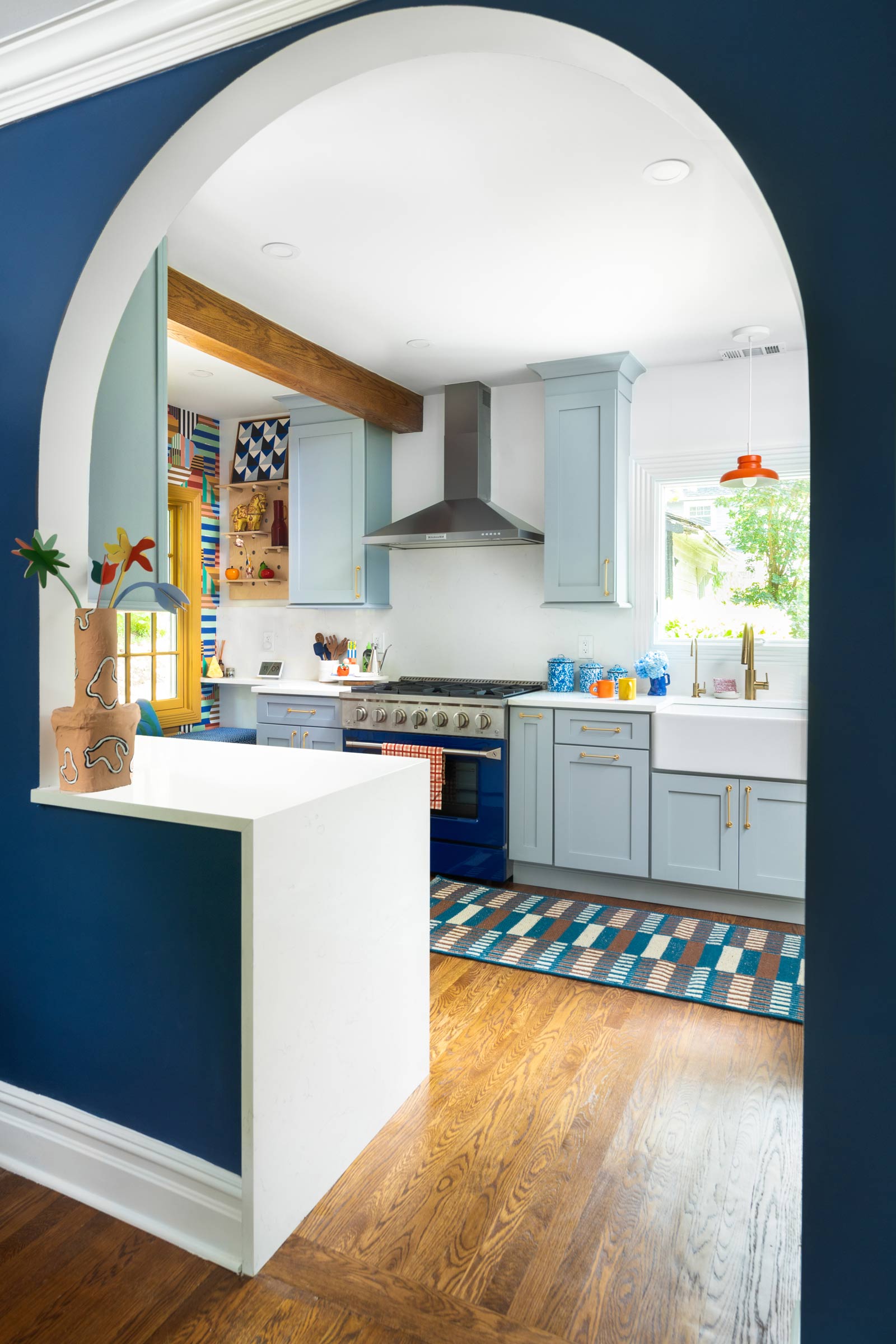 After a kitchen remodel with a blue archway and a red pendant over the sink.