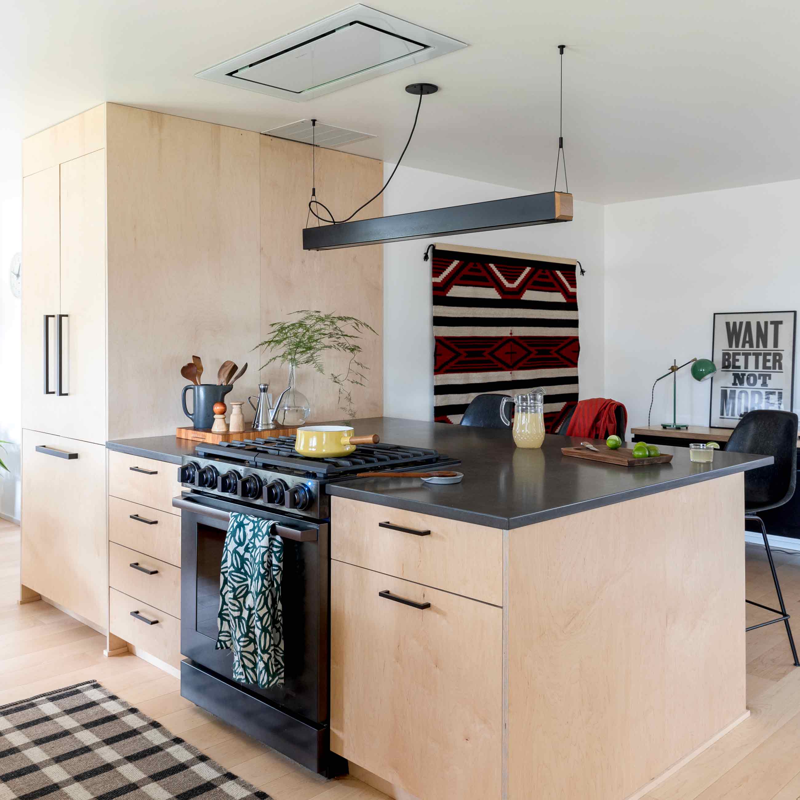 A modern kitchen island with light wood and black accents. 