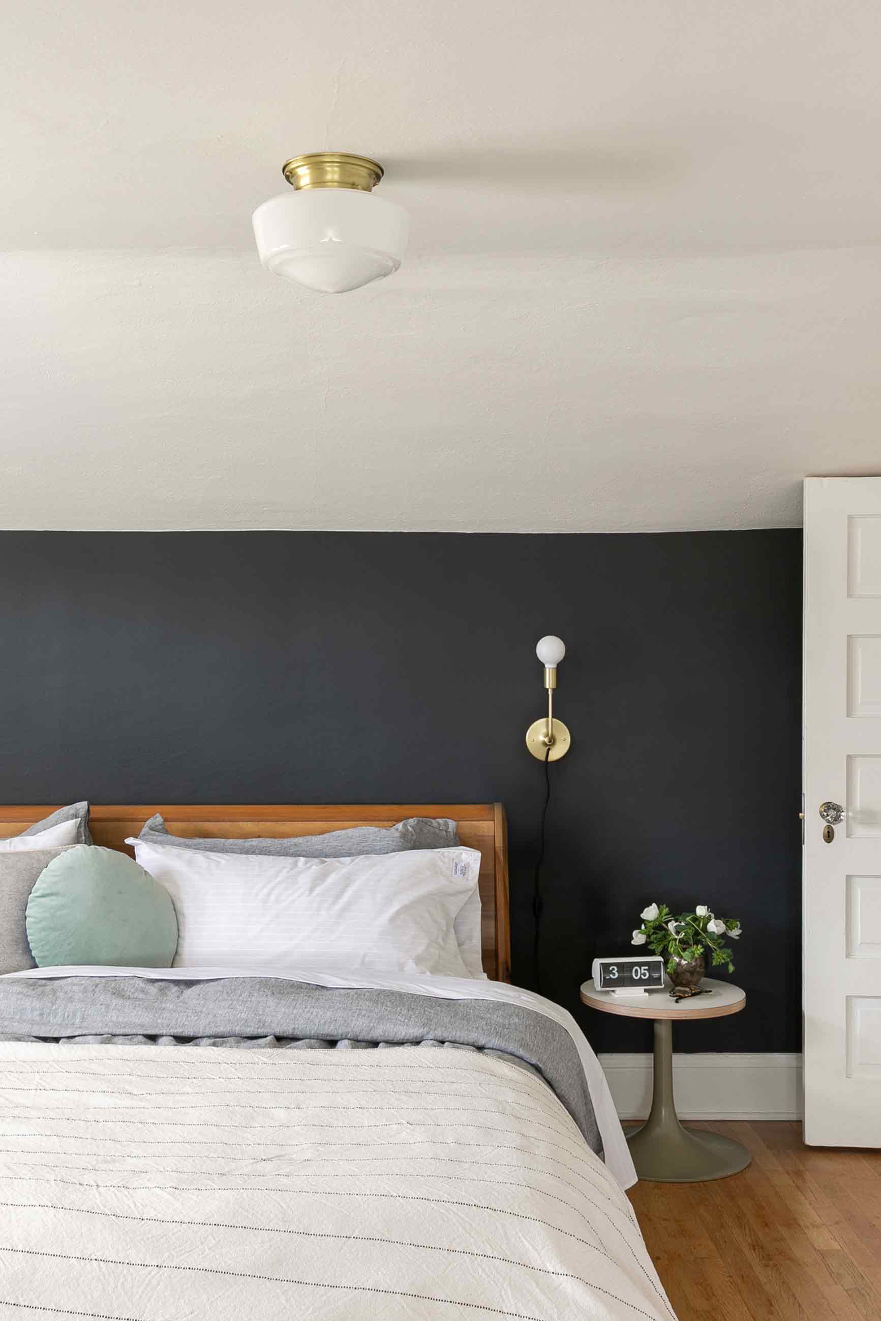 Serene bedroom with navy blue wall and calming cream bedding.