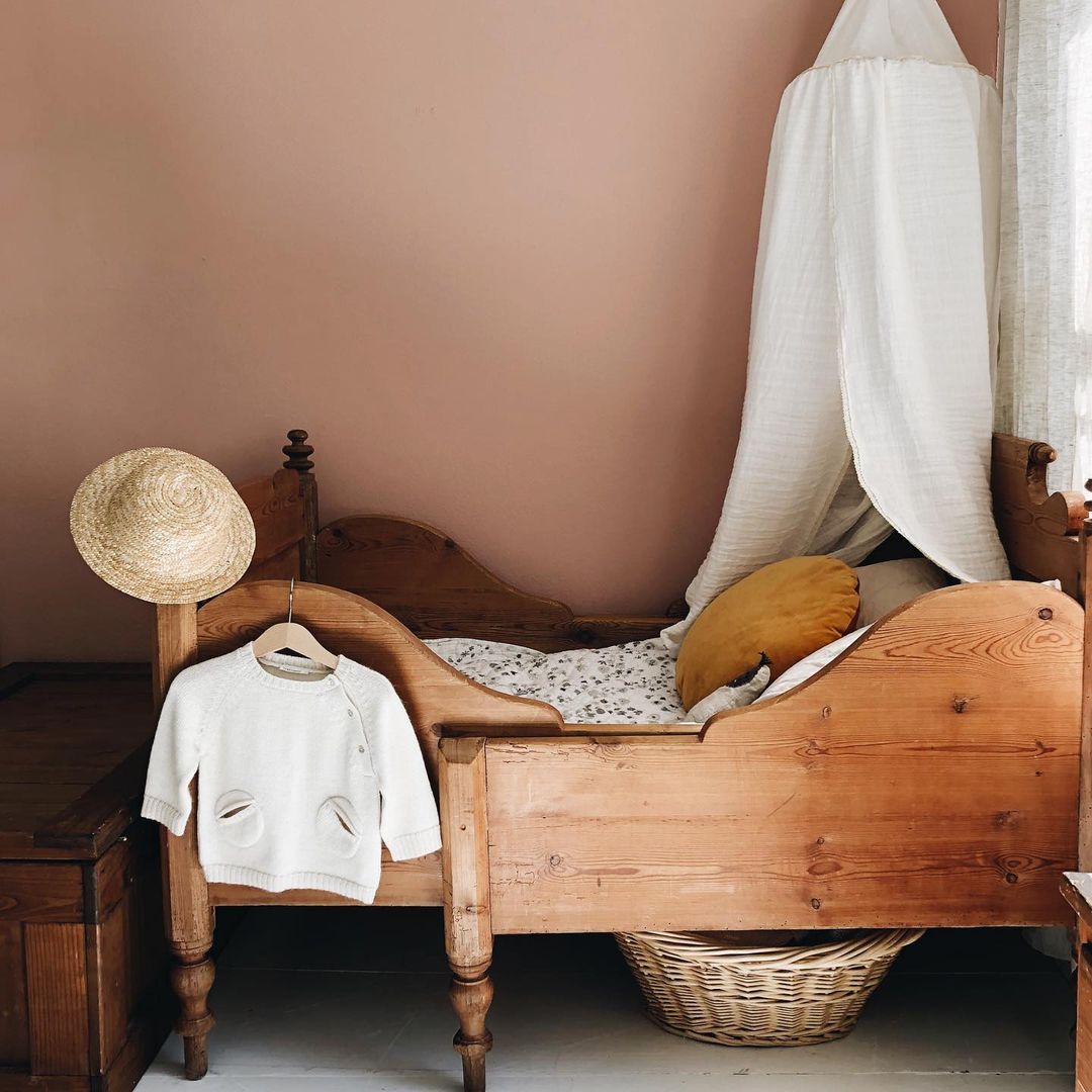 child's bed with a basket and a canopy