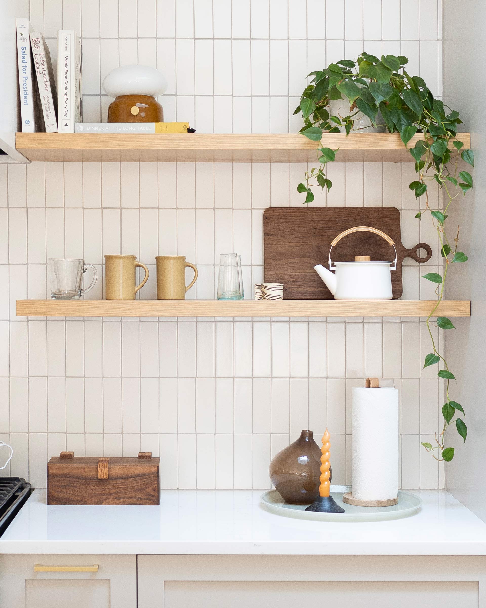 Open shelving on a modern, tiled kitchen wall.