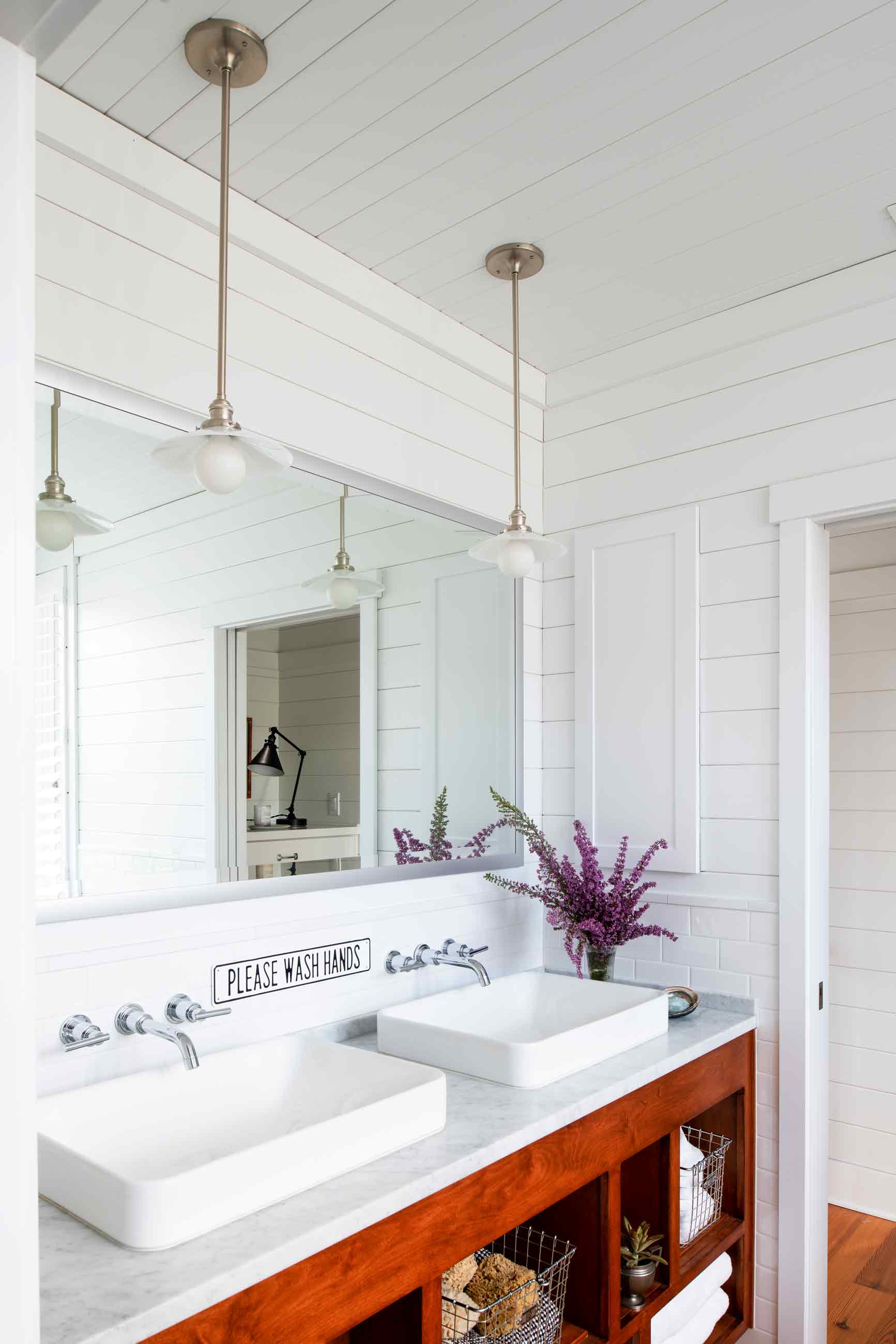 Brass pendants hanging above bathroom sink. 