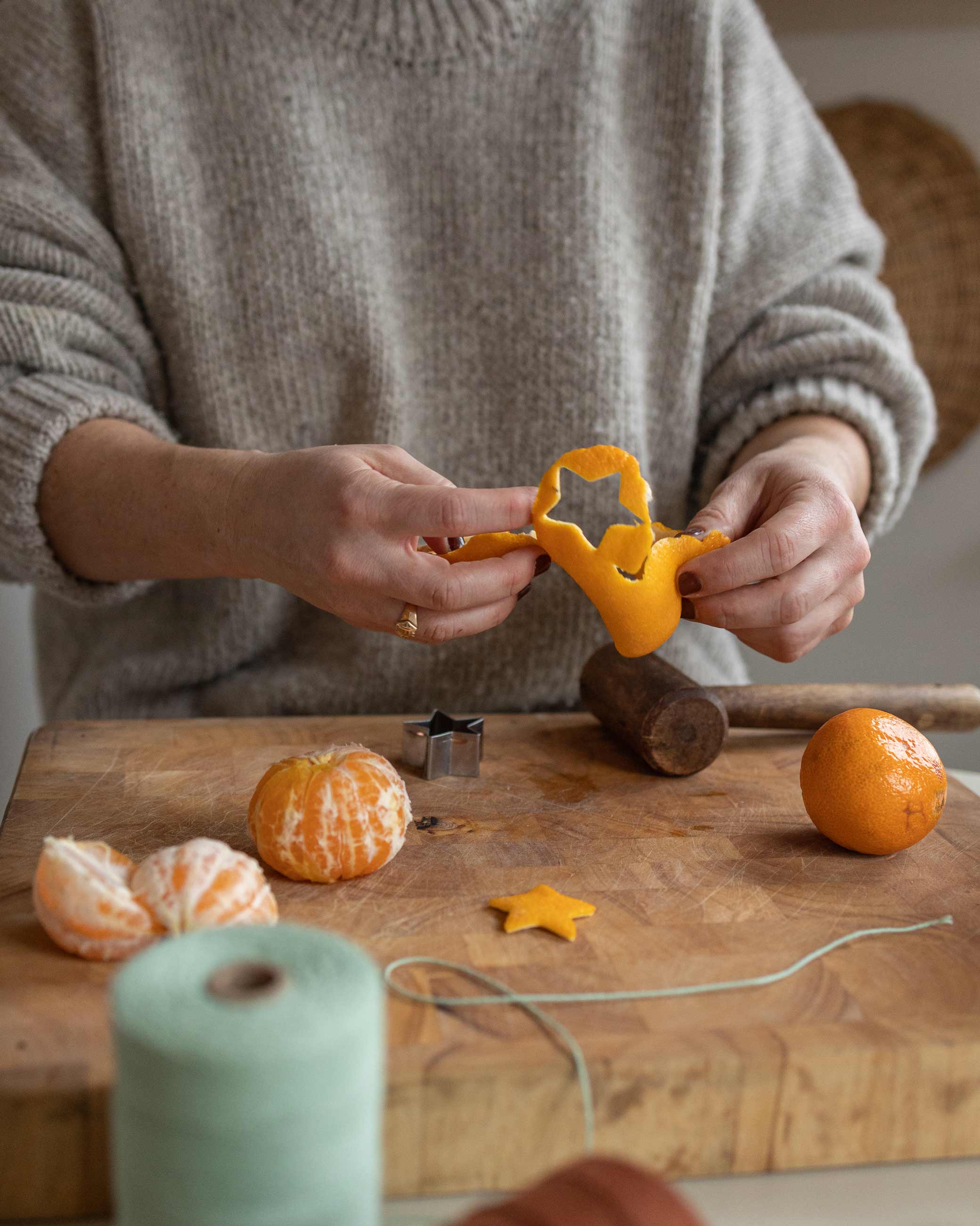 Person cutting star shape out of mandarin skin.
