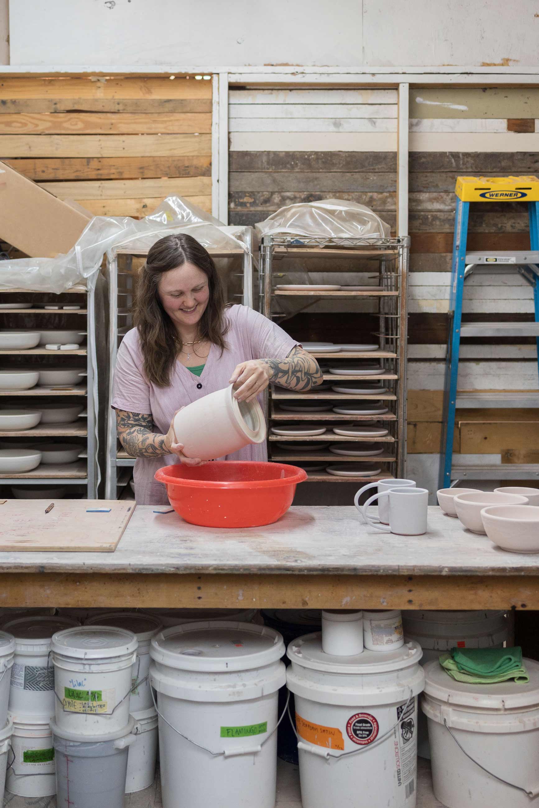 Person holding ceramic pot in a ceramics studio. 