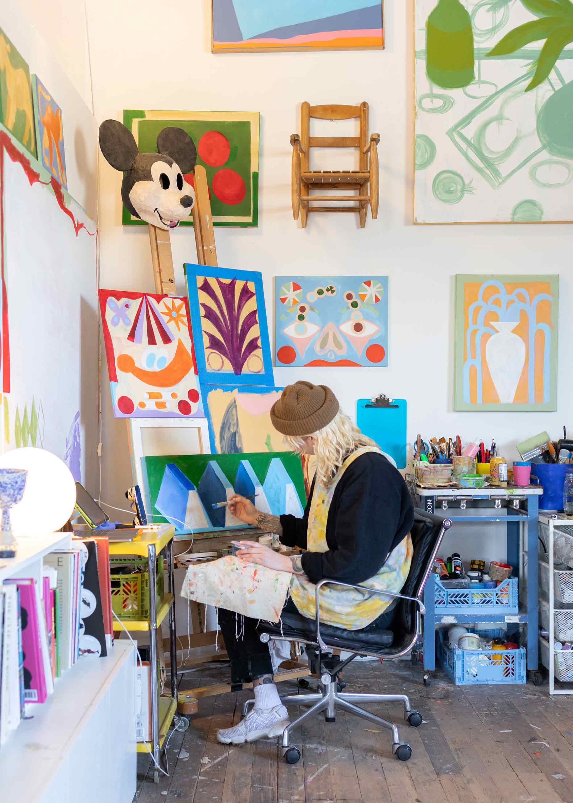 Person sitting in chair painting in art studio. 