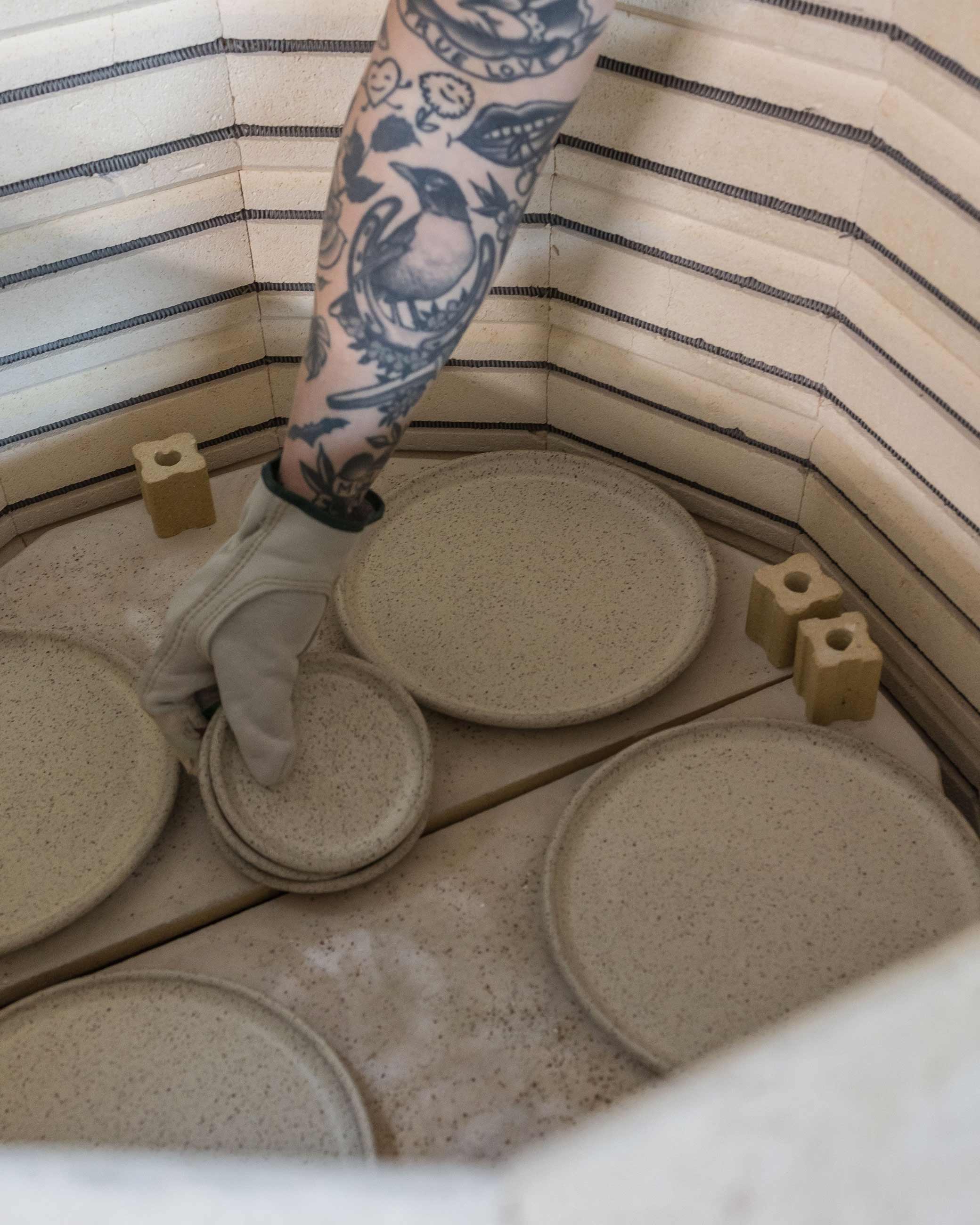 Person removing fired ceramics from kiln