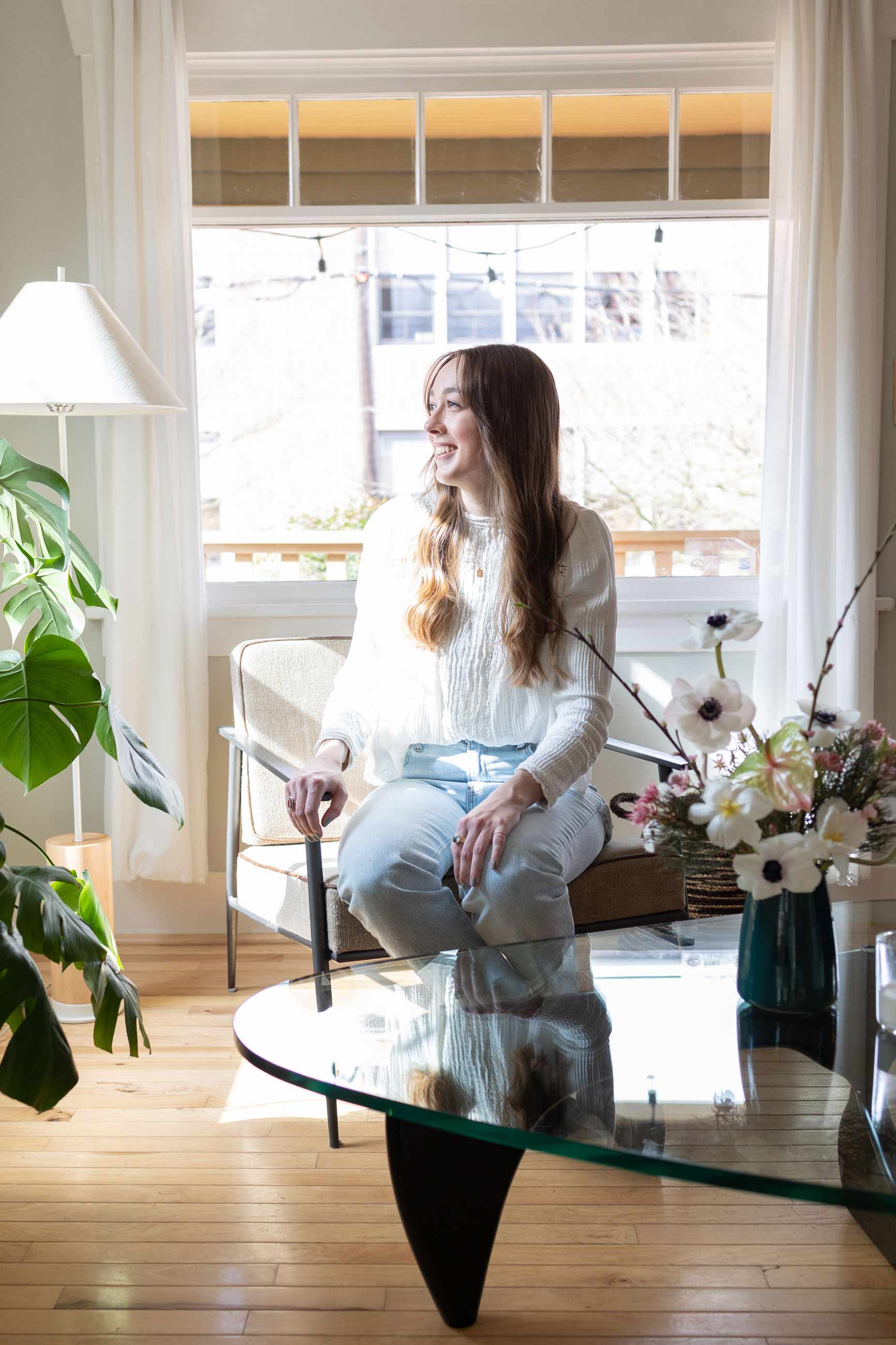 Person sitting in mid century chair by big window. 