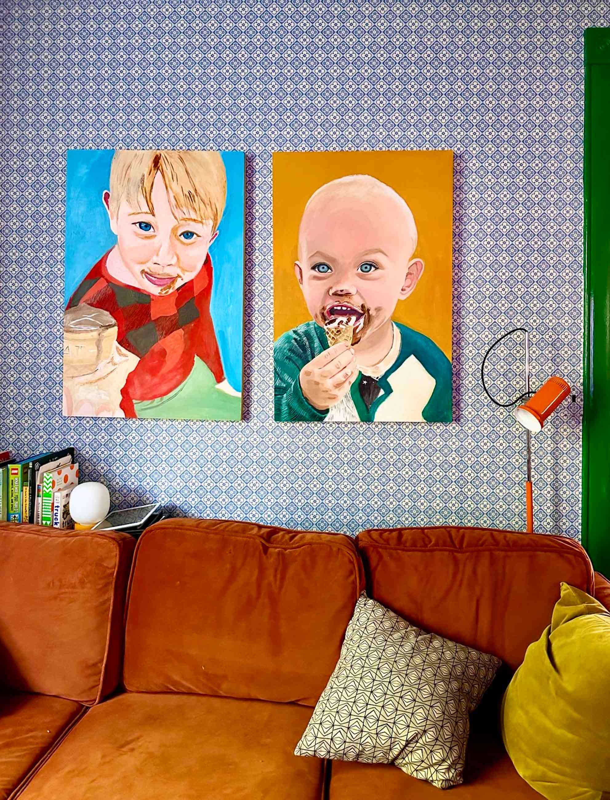 Portraits of children hanging over couch in living room.