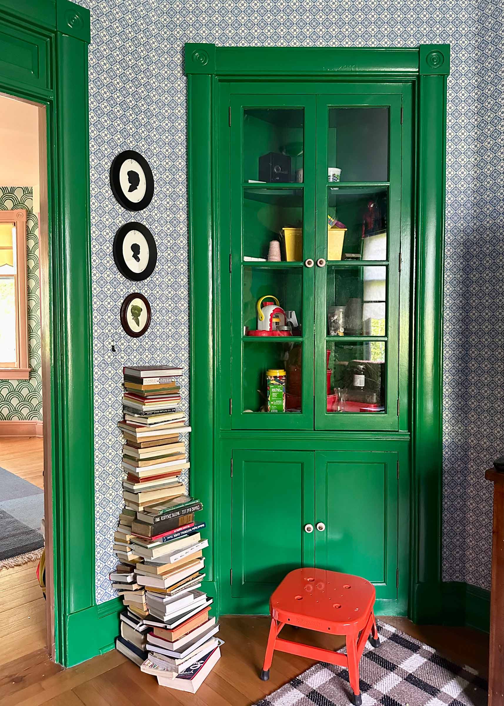 A red step stool in a living room nook.