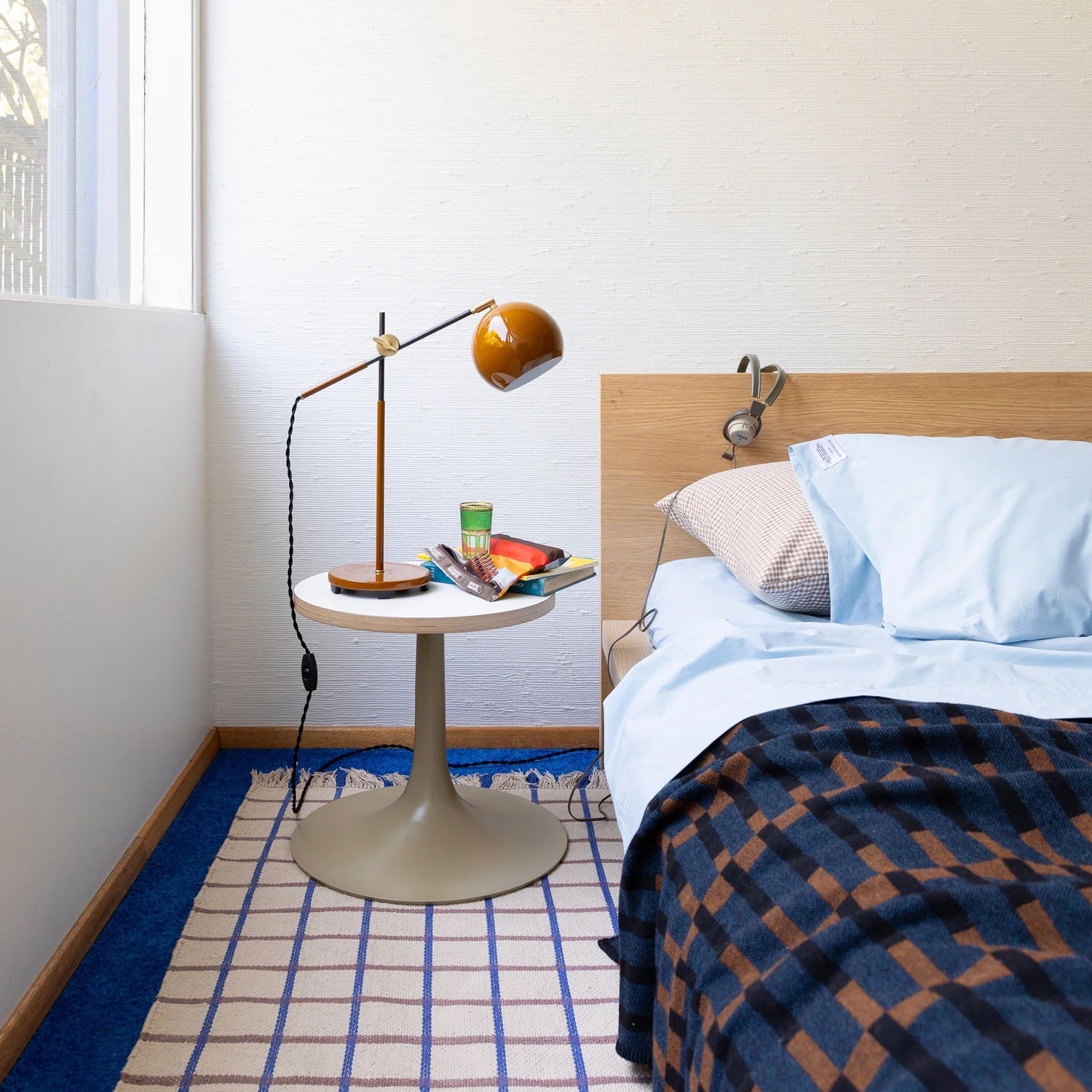 Grid rug on floor of bedroom.