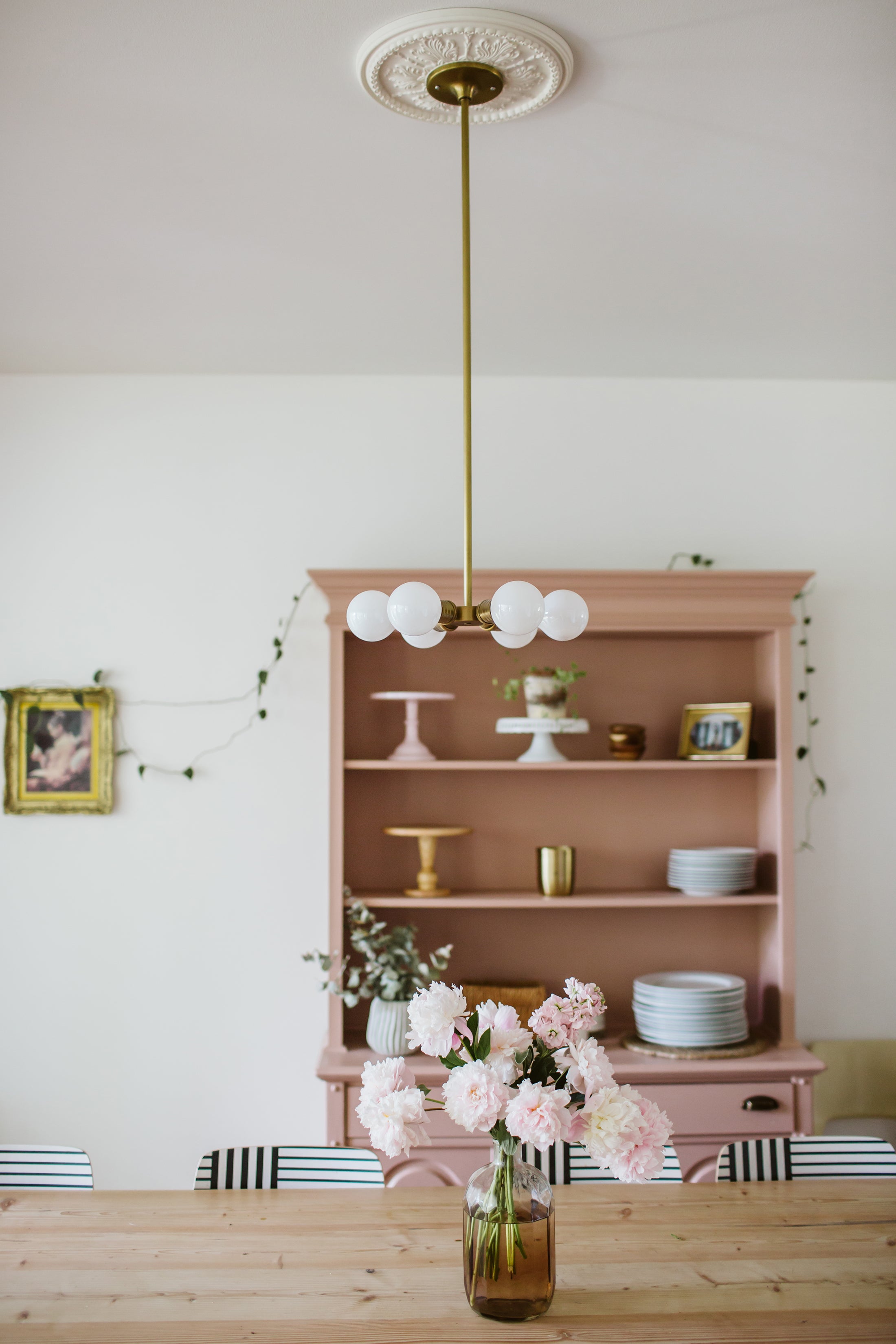 vase of flowers on a table and pink cabinet