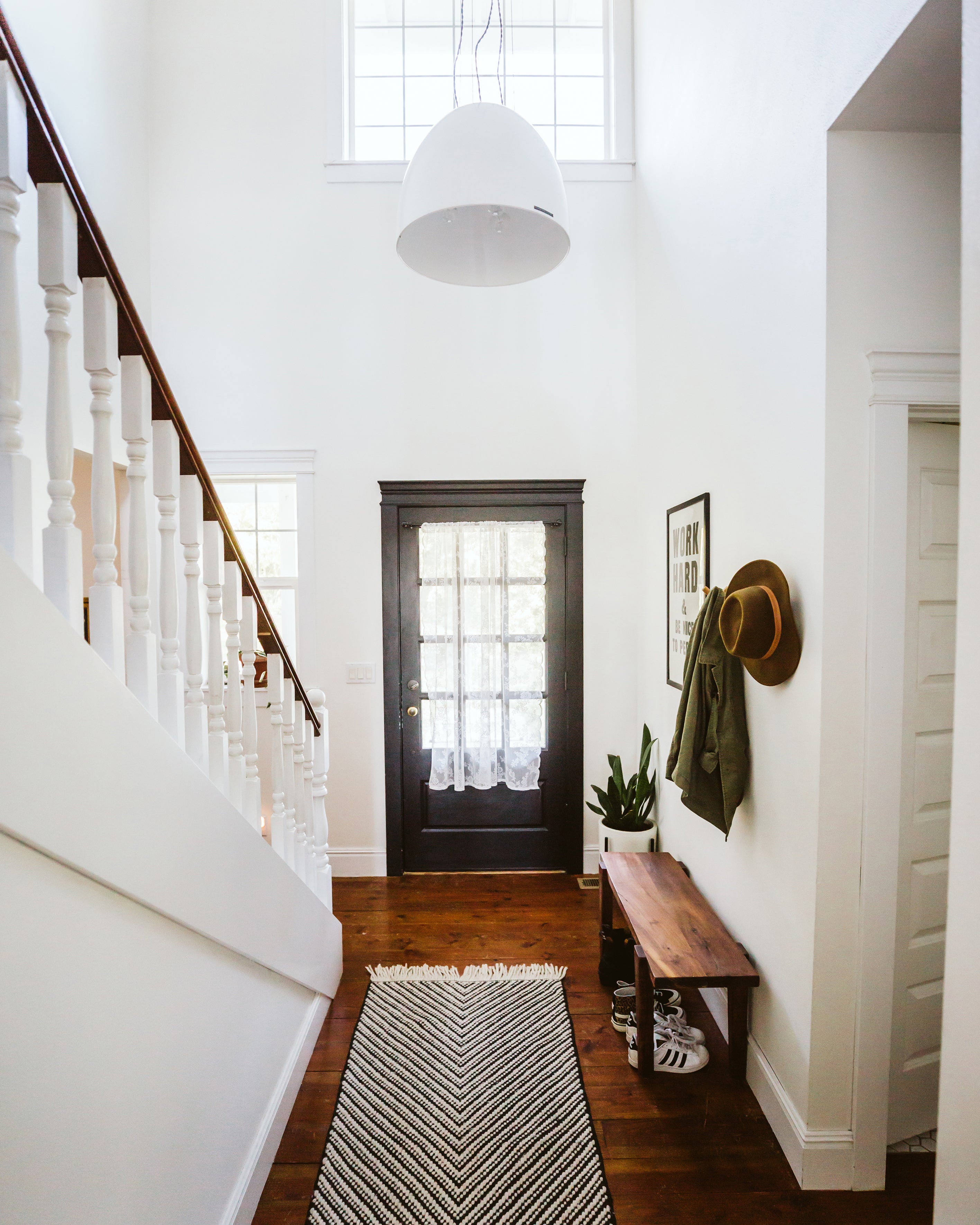 white staircase with a light fixture above it and a door 