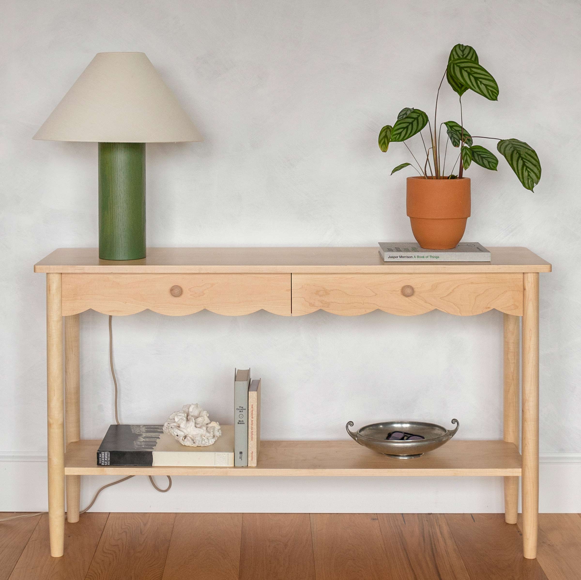 Sideboard with table lamp and plant on top.