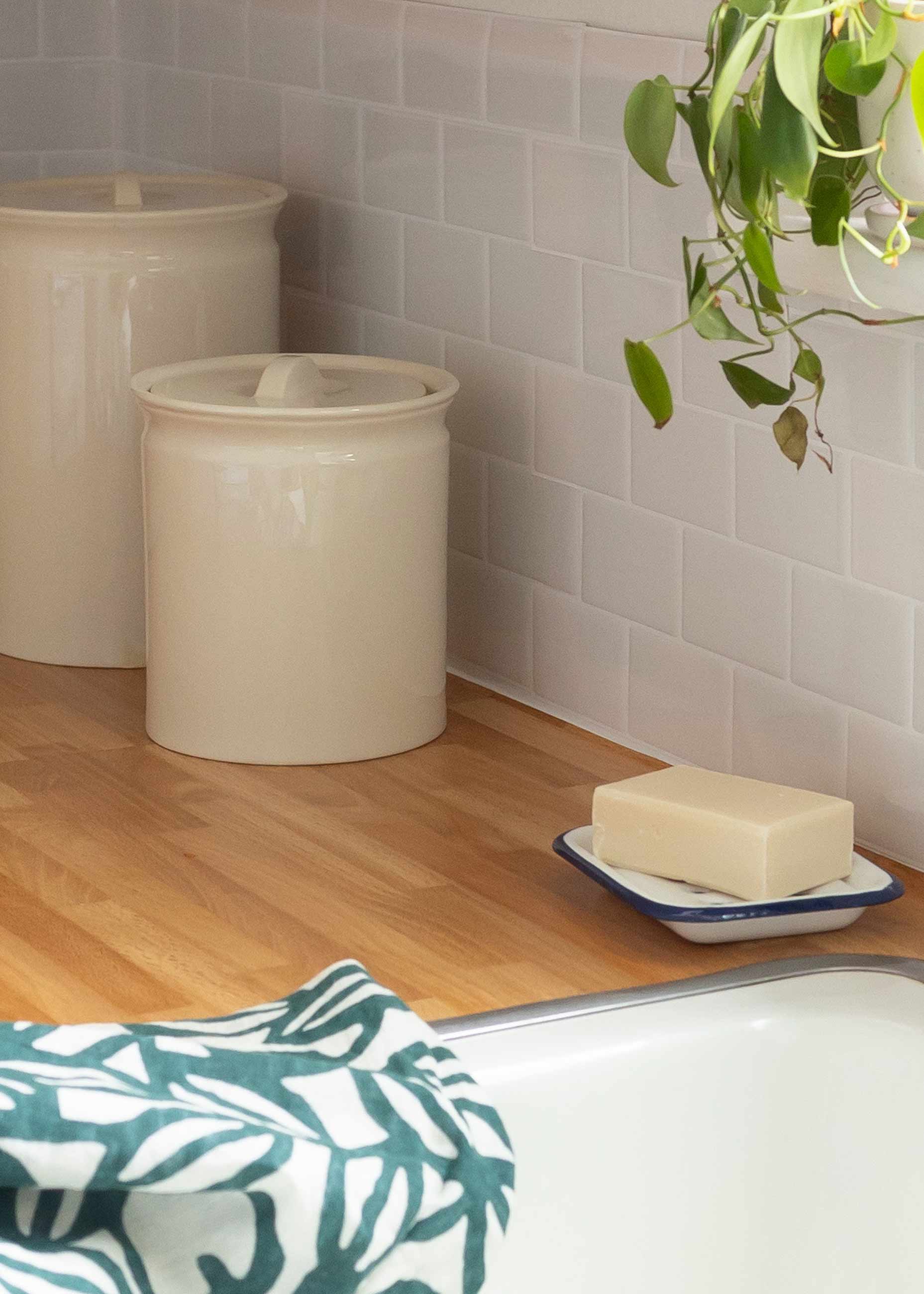 Soap dish and towel on counter next to white sink. 