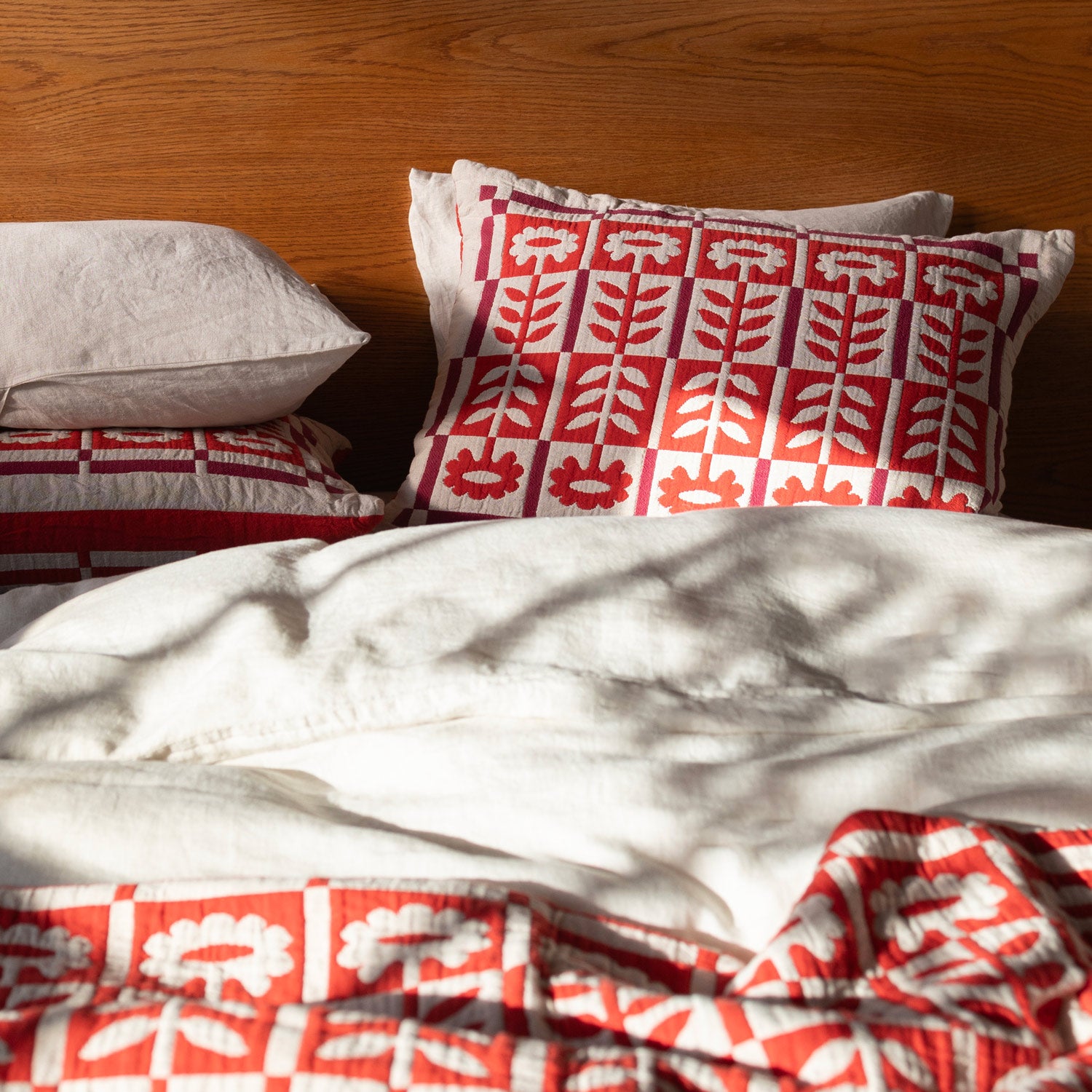 Stillwater floral quilt in red on a bed.