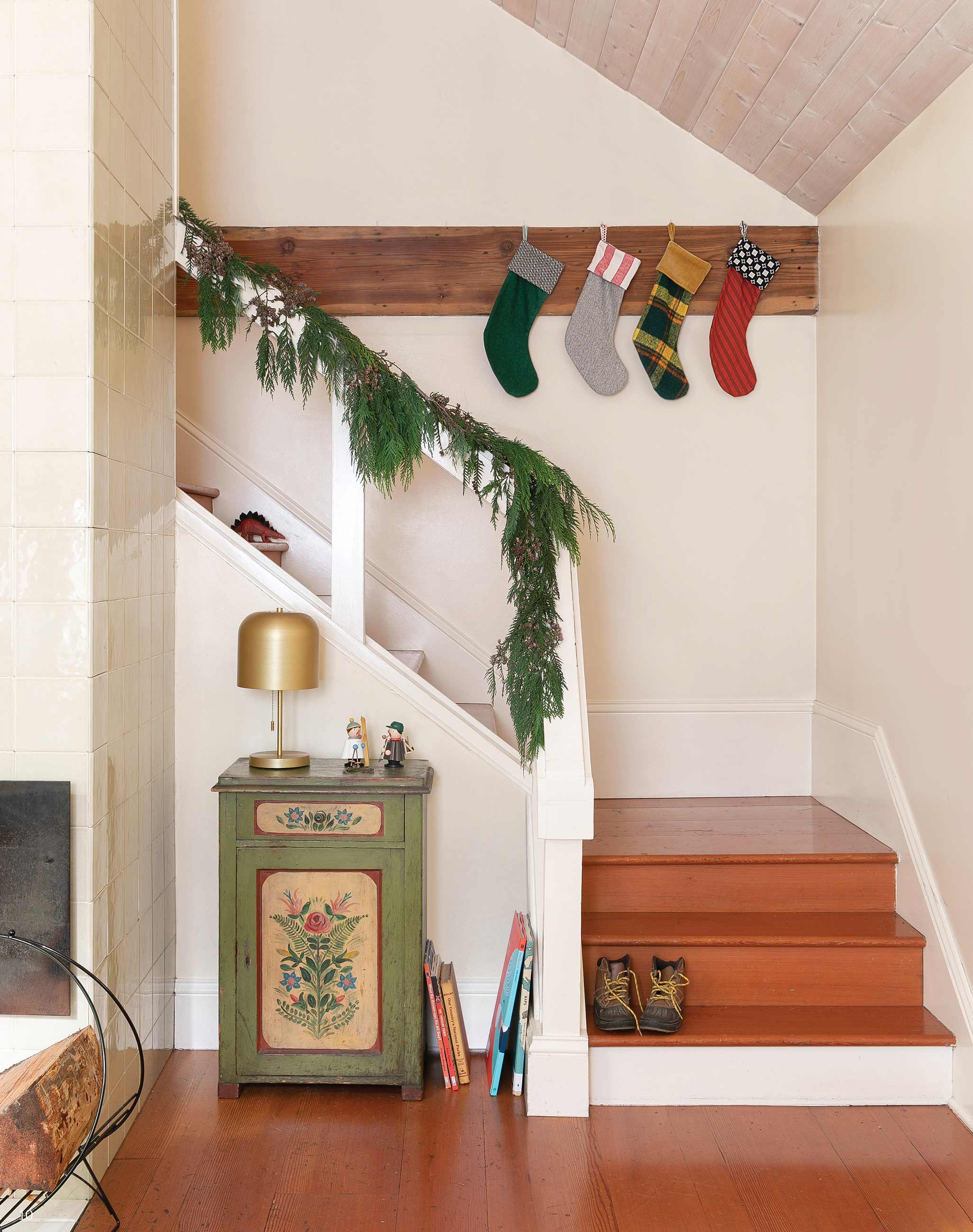 Colorful stockings hanging from wooden peg rail on staircase landing.