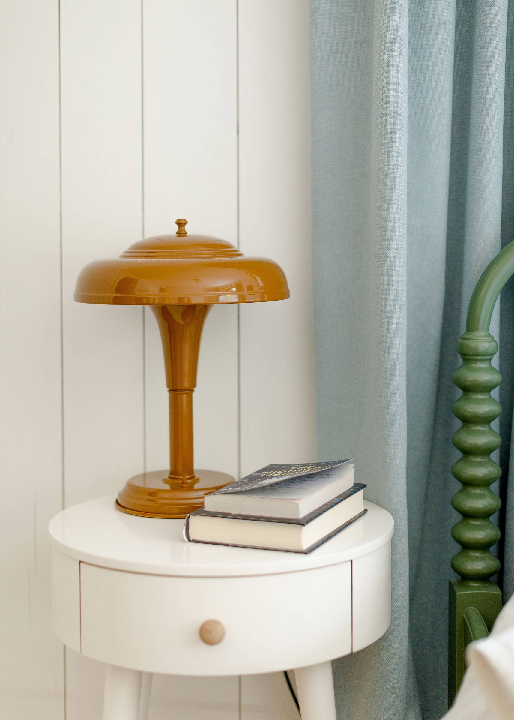 The Graduate Table Lamp in butterscotch on a bedroom side table. 